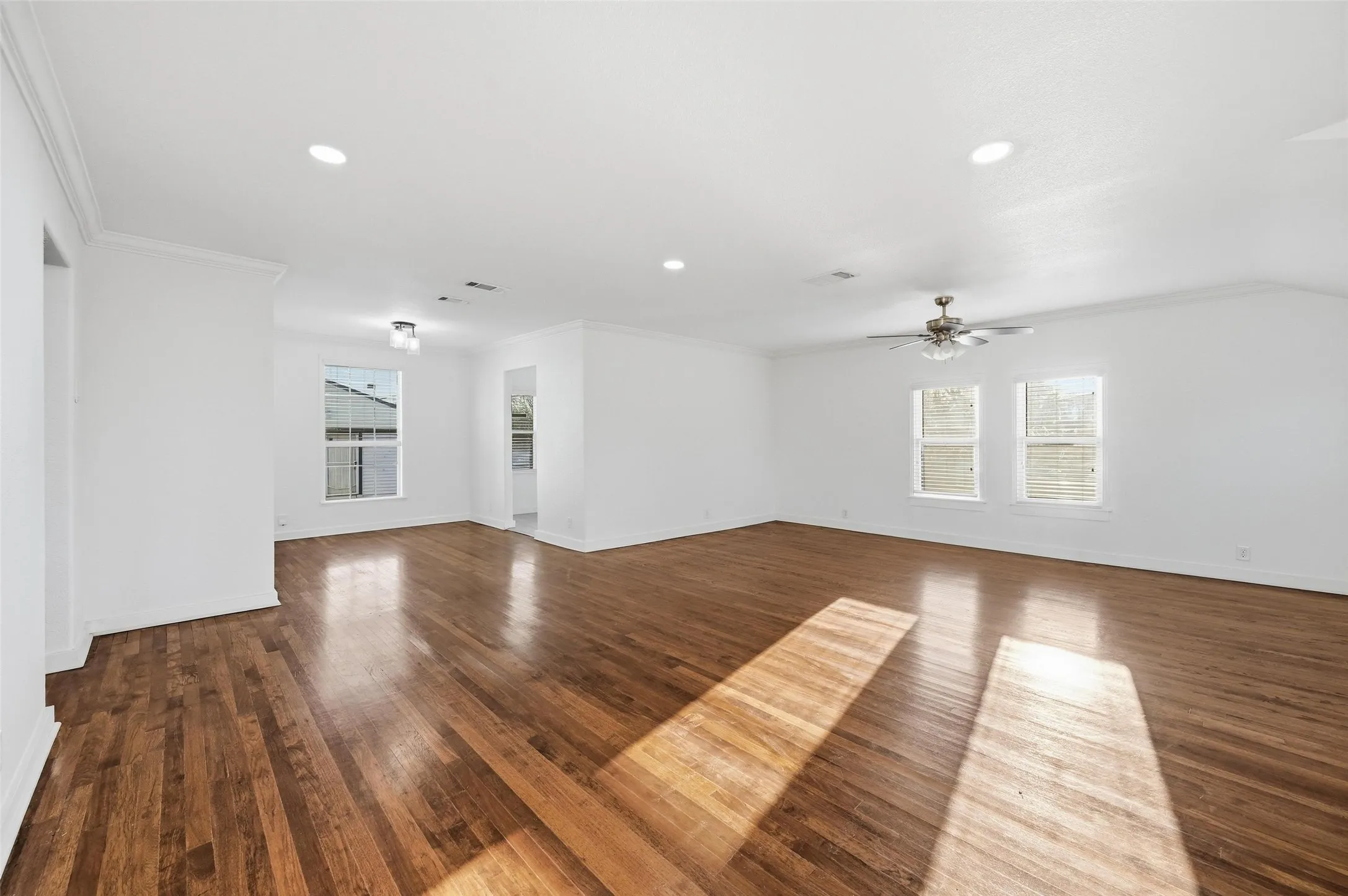 Unfurnished living room with recessed lighting, dark wood finished floors, ornamental molding, and a ceiling fan