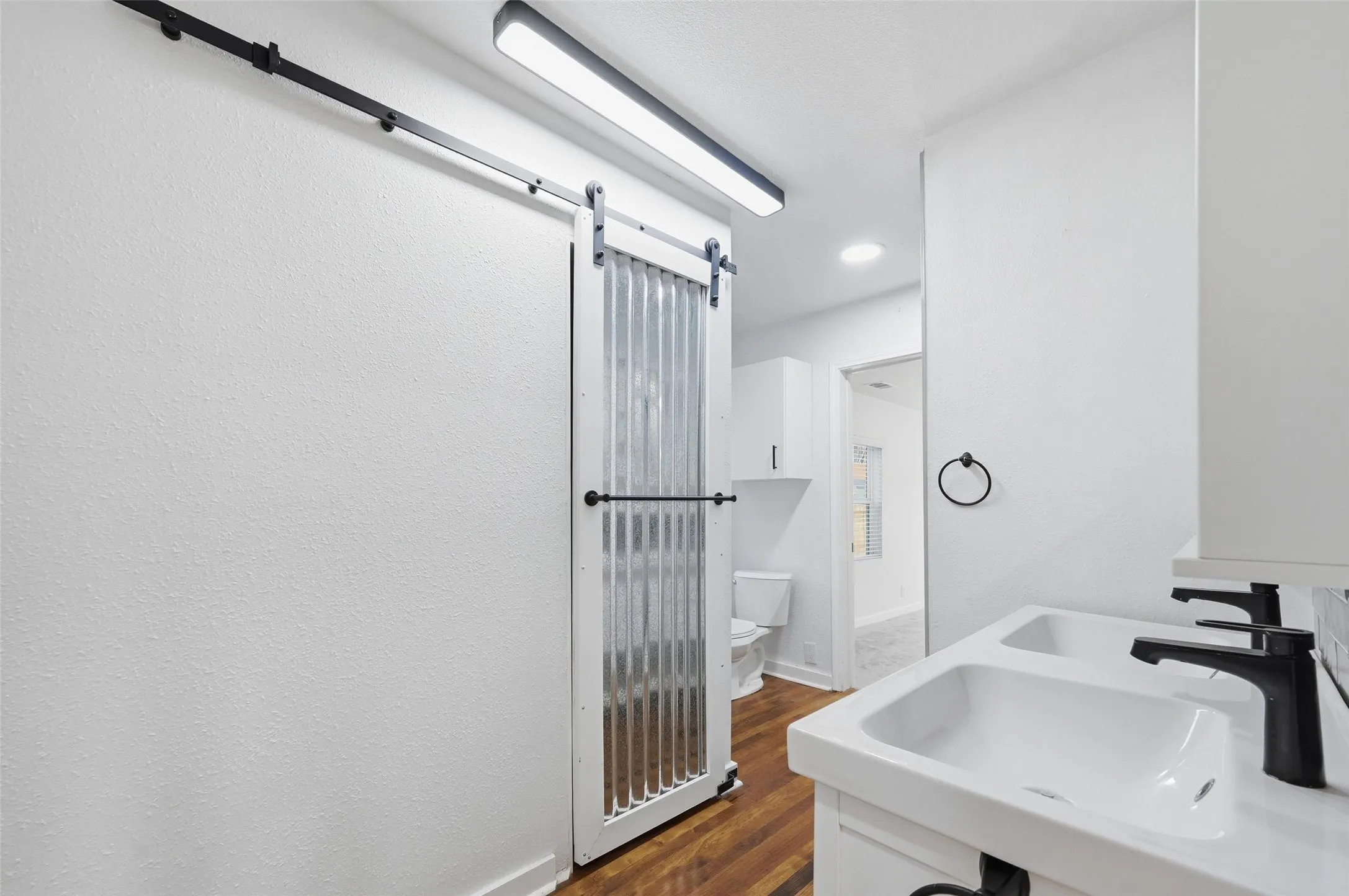 Bathroom featuring dark wood-style floors and double vanity