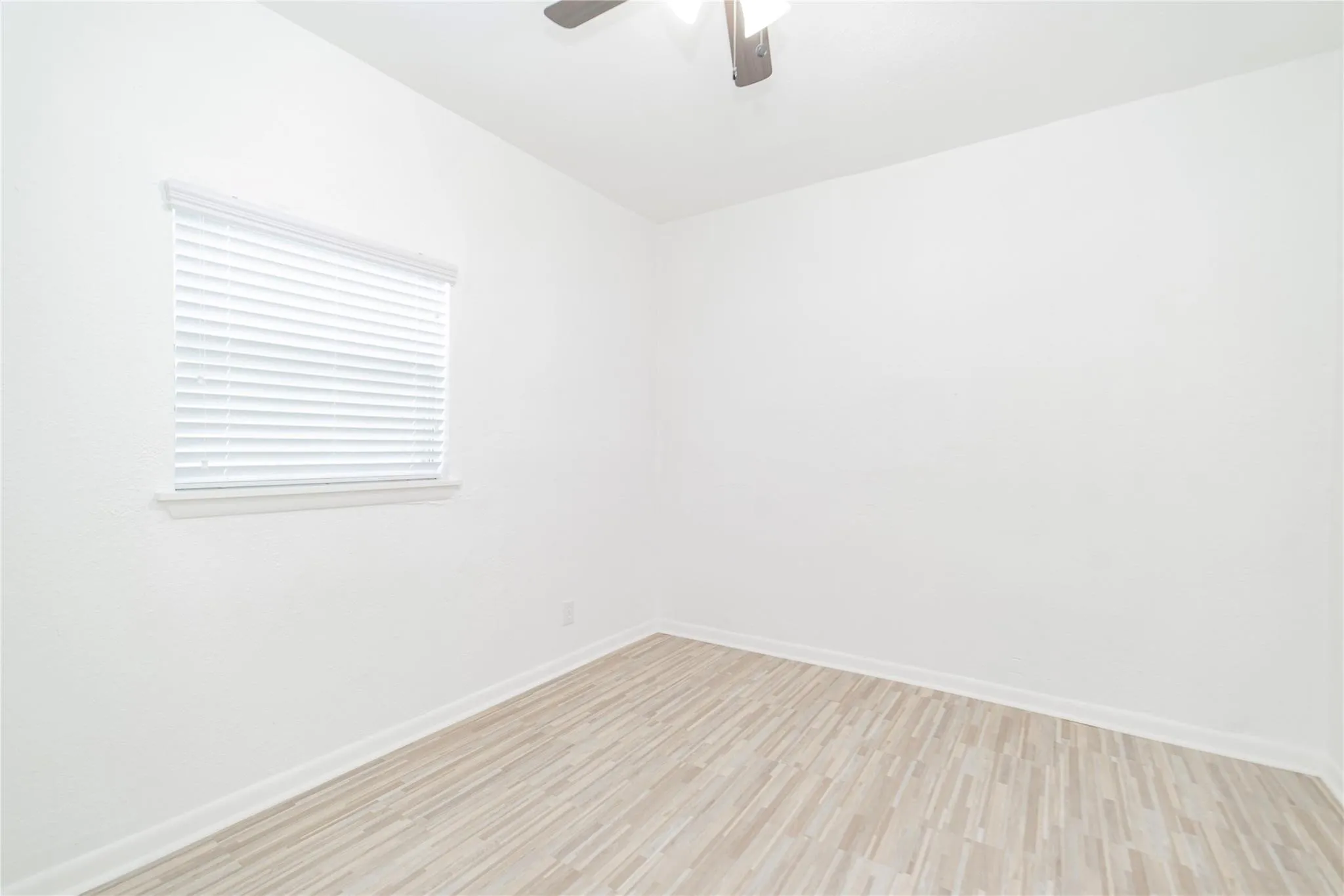 Spare room with light wood-style flooring and a ceiling fan