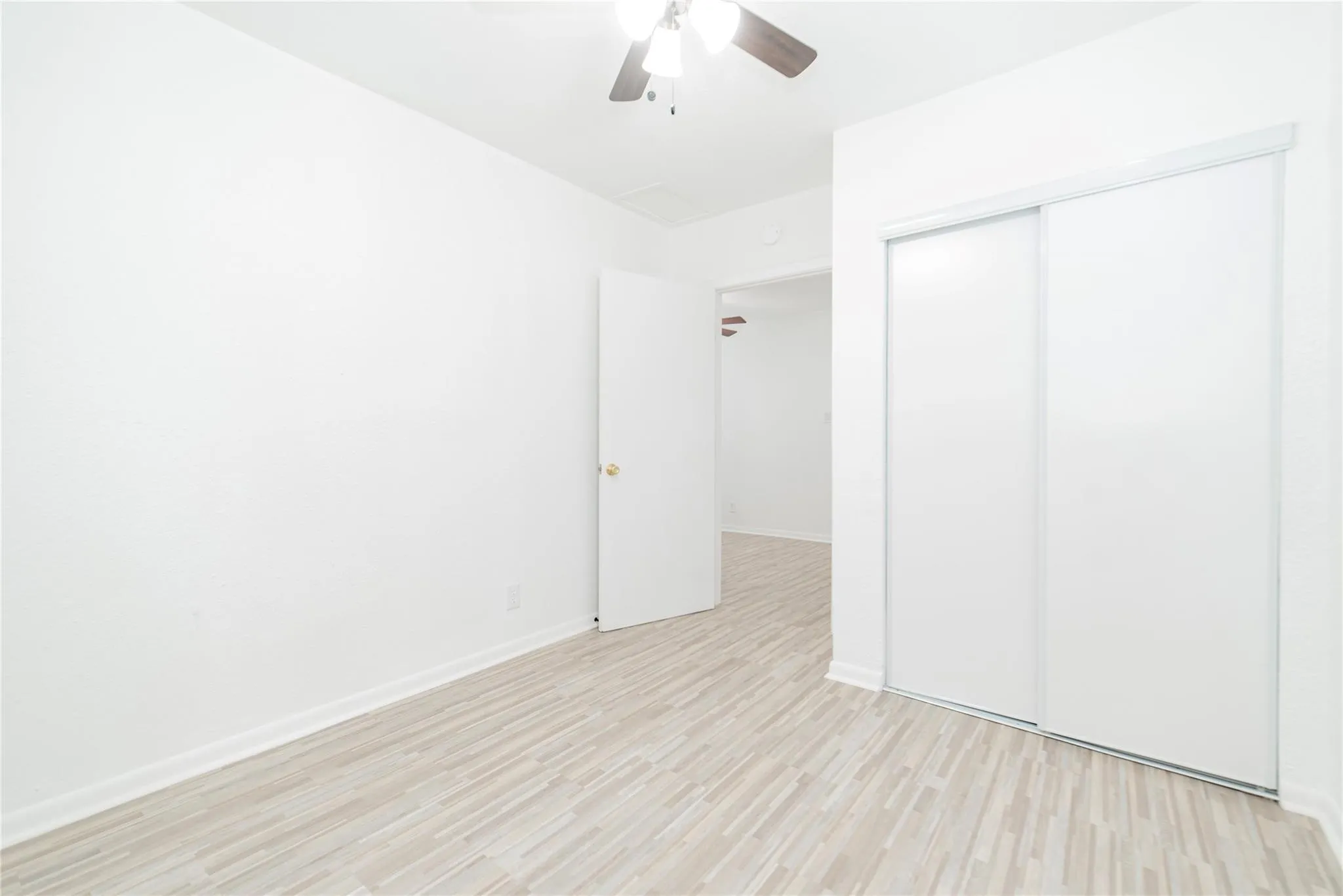 Unfurnished bedroom featuring light wood-style flooring, ceiling fan, and a closet