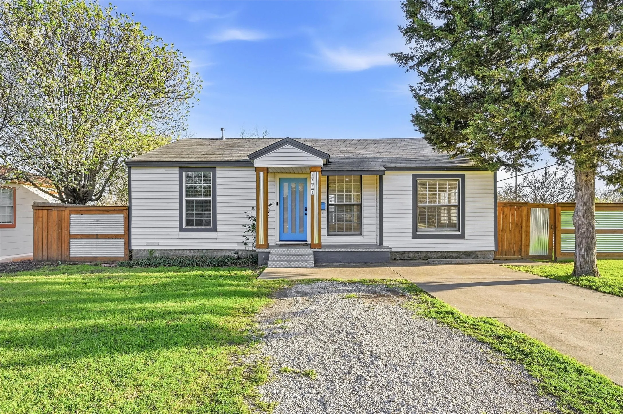 Bungalow with roof with shingles and concrete driveway