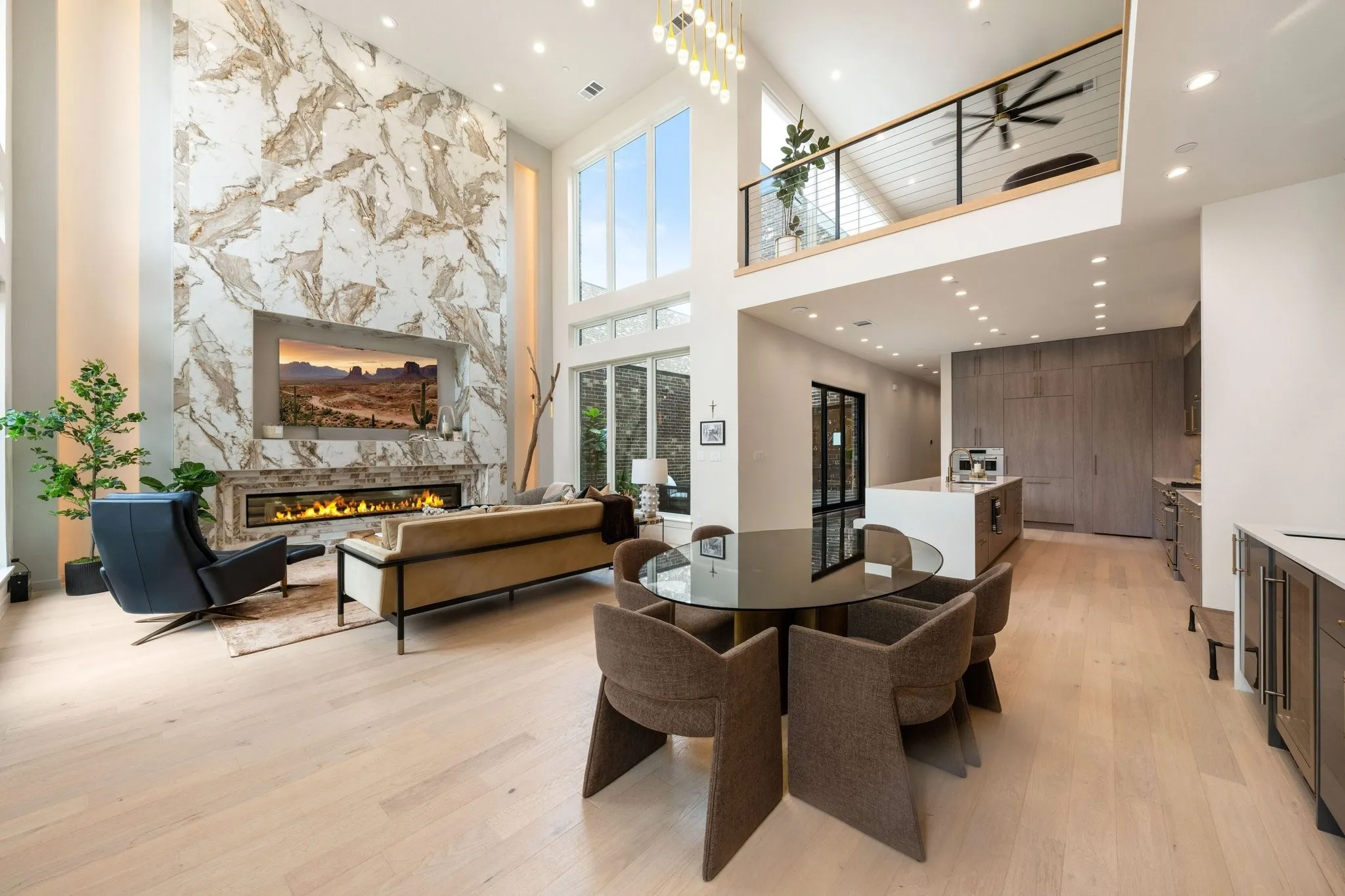 Dining area featuring a high ceiling, open to living a fireplace, recessed lighting, and light hardwood flooring