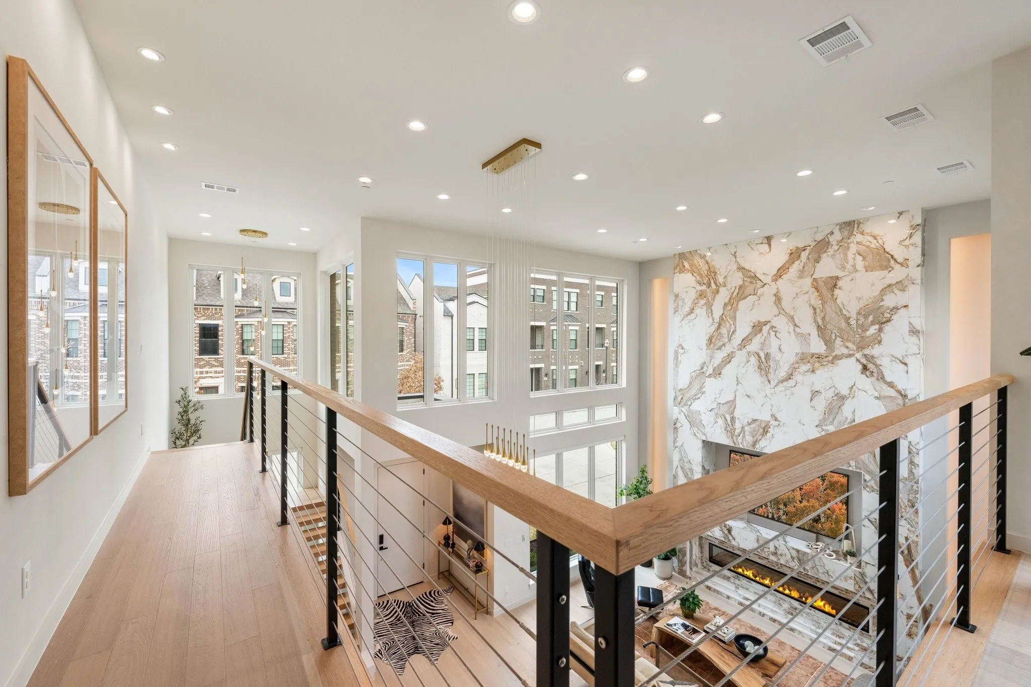 Corridor featuring an upstairs landing, light wood finished floors and modern railing
