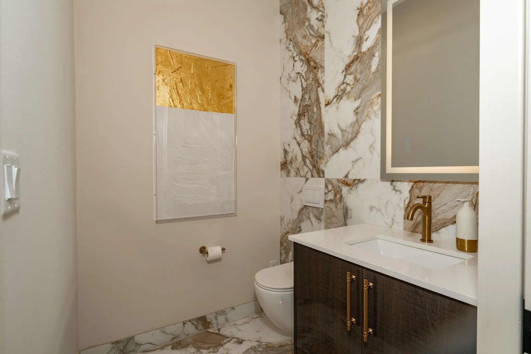 Half bathroom featuring light marble like floors and vanity