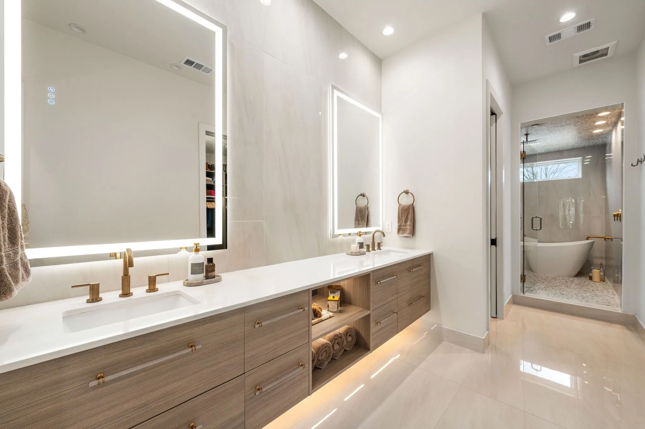 Full bathroom with double lighted vanity, that leads to spa like wet room