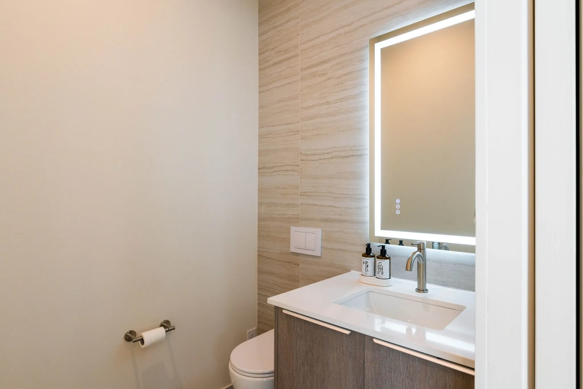 Half bathroom with vanity and tile walls