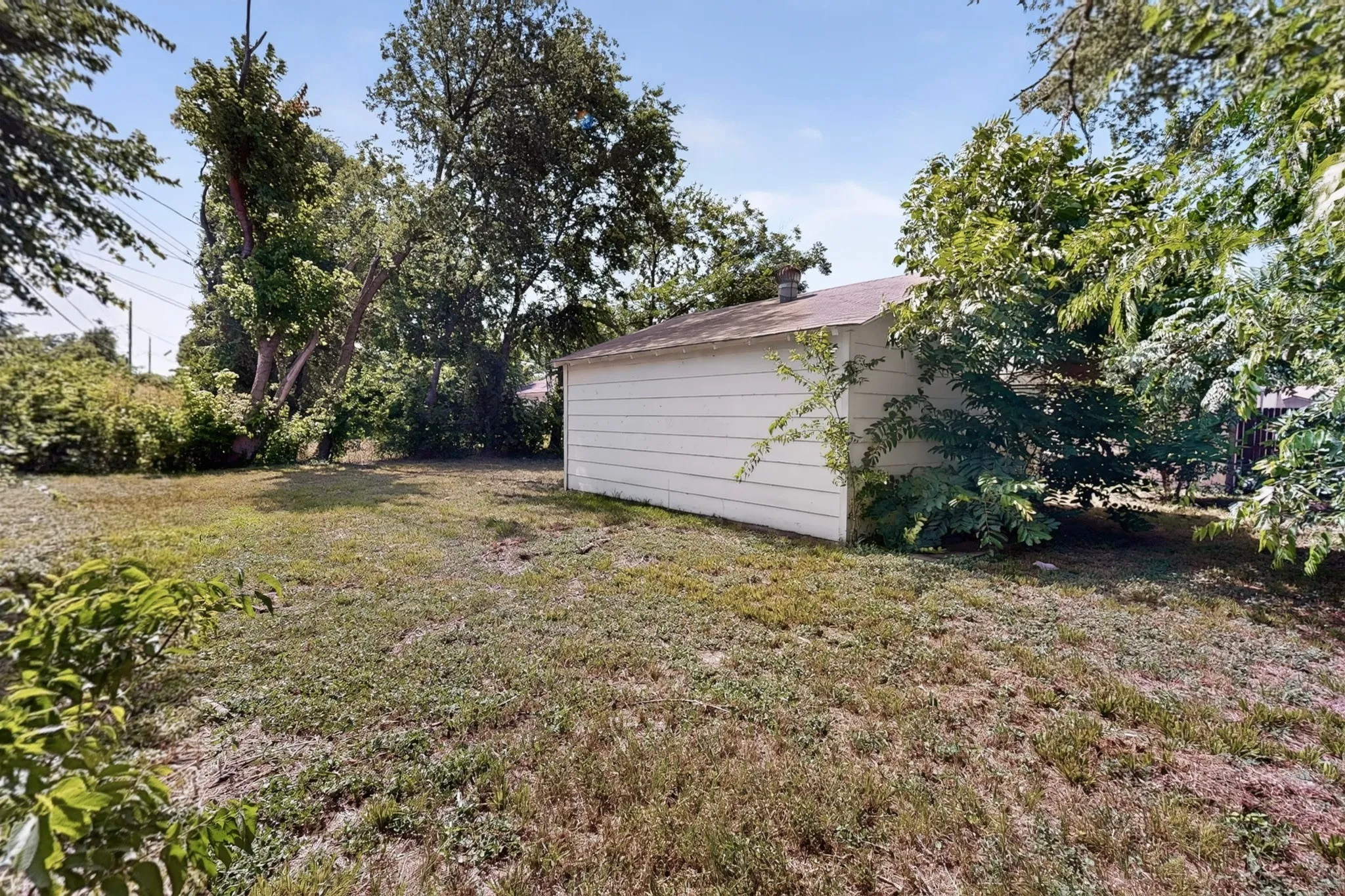 Detached garage structure with white horizontal siding and a flat roof