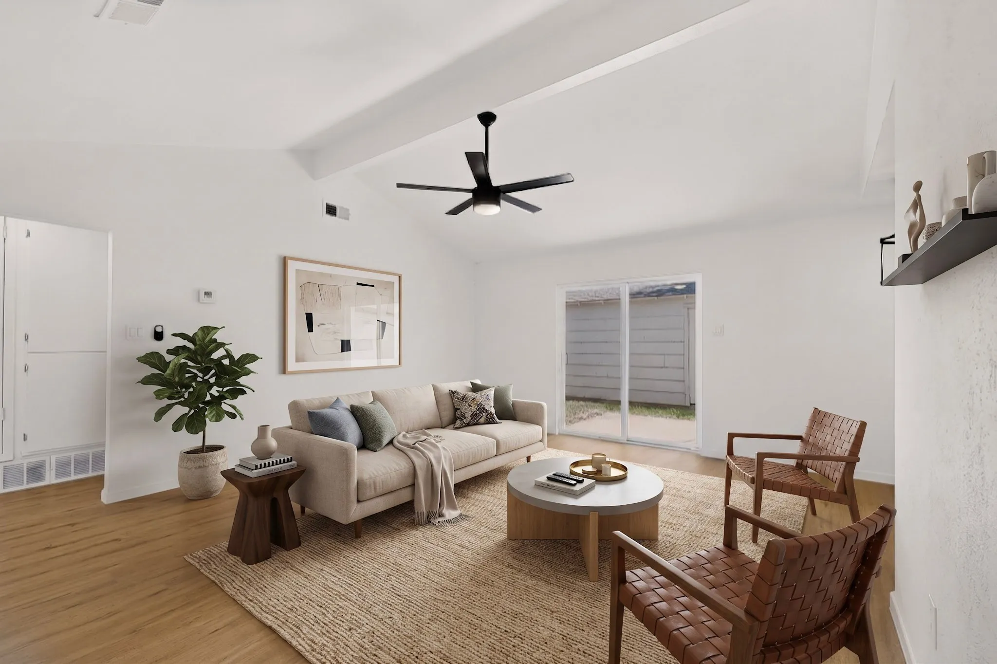 Bright living area featuring a vaulted ceiling and wood-finish flooring