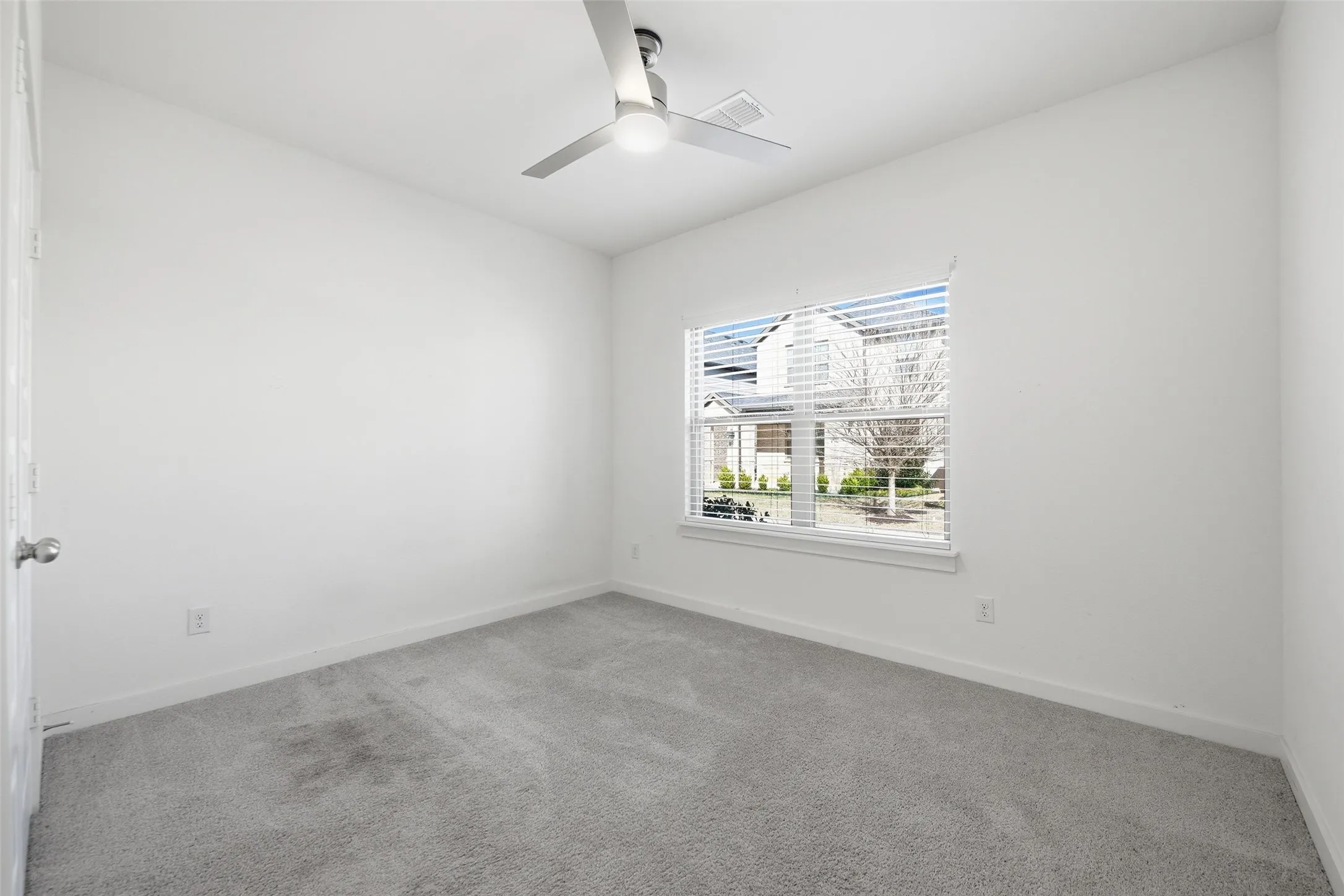 Spare room featuring carpet and ceiling fan
