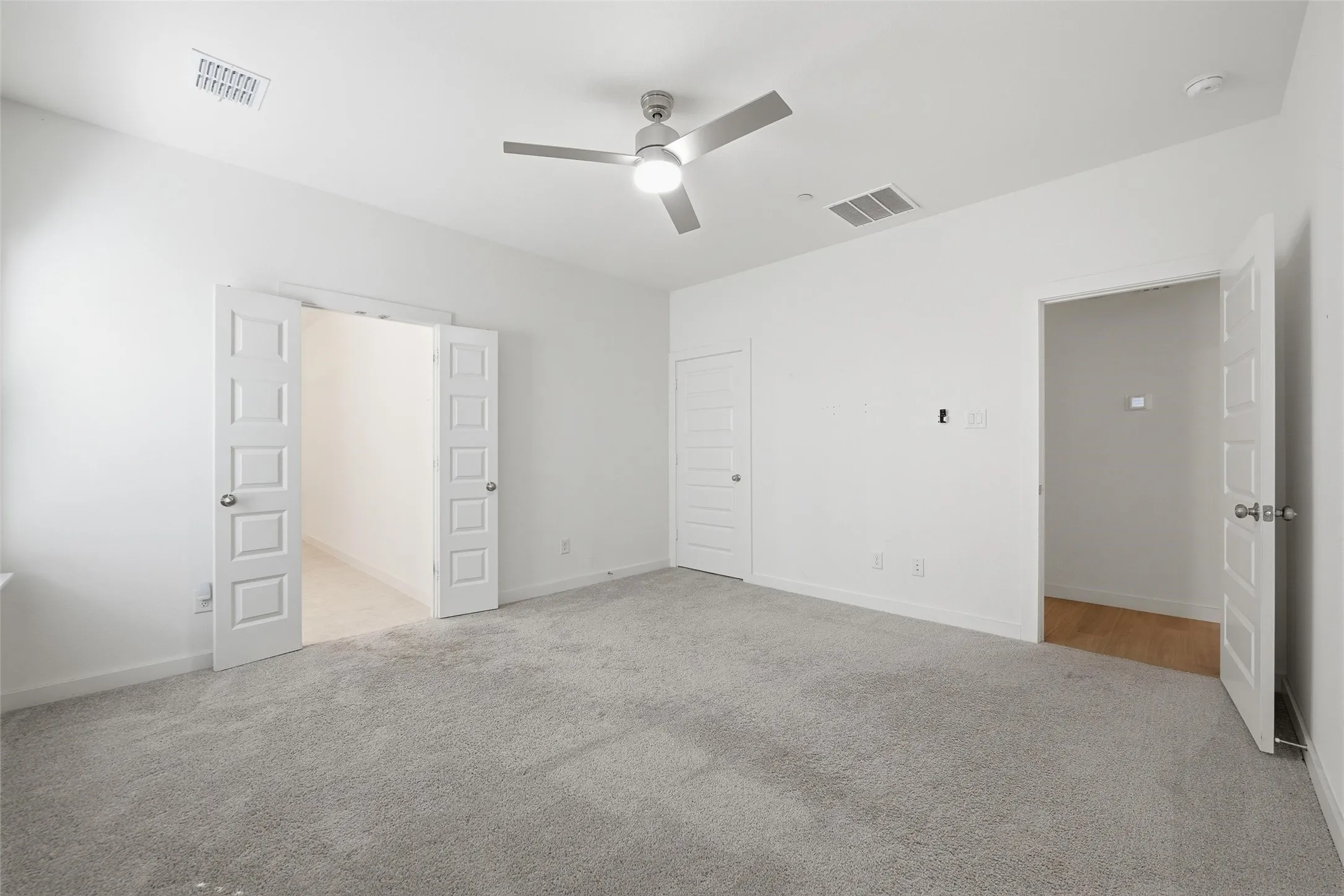 Unfurnished bedroom featuring light colored carpet and ceiling fan