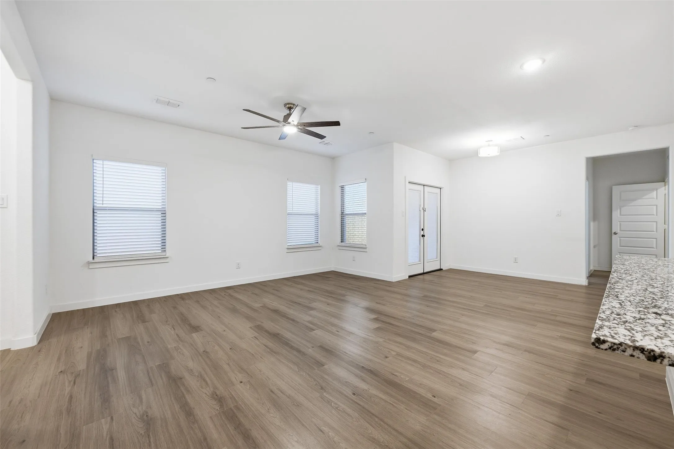 Unfurnished living room featuring dark wood finished floors and a ceiling fan