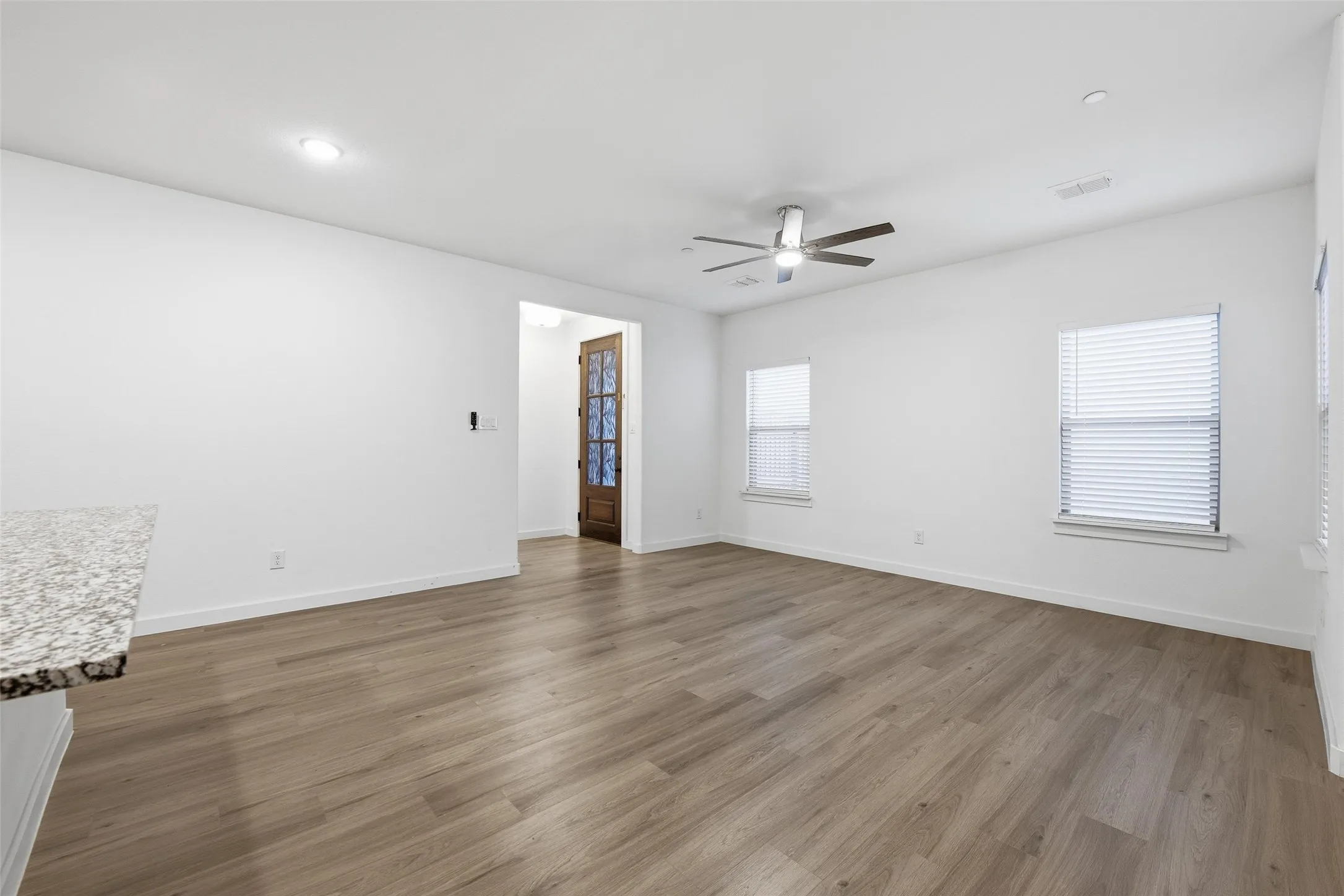 Empty room with ceiling fan, dark wood-style floors, and recessed lighting