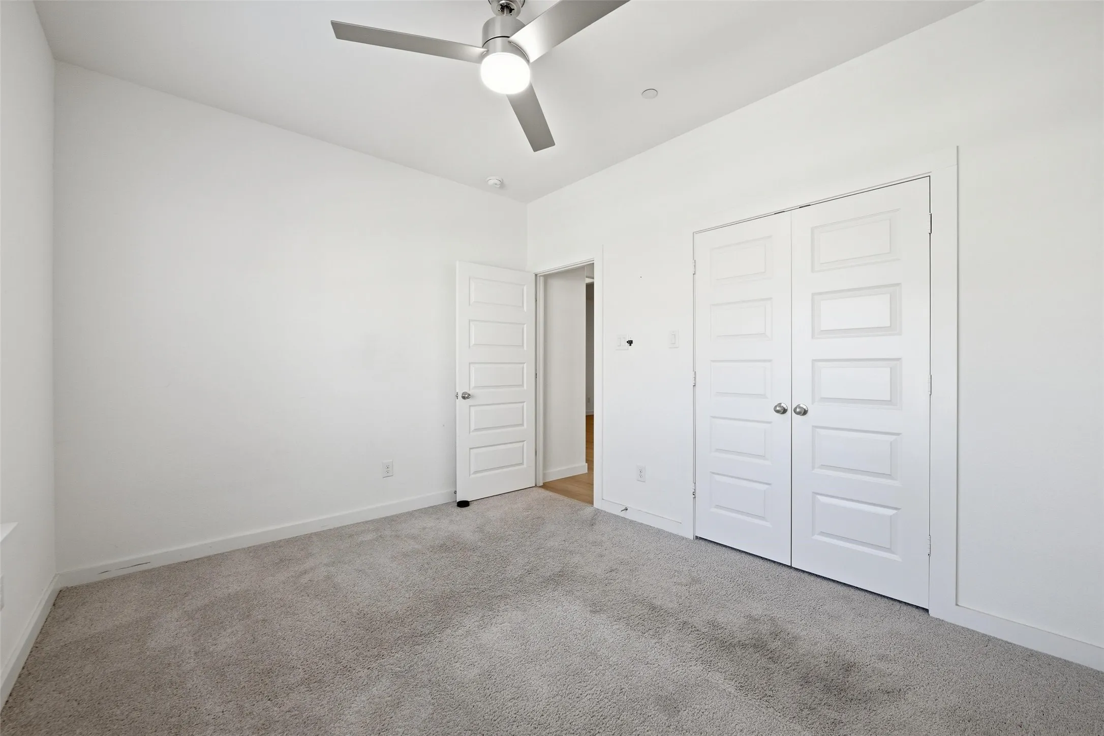 Unfurnished bedroom featuring carpet, ceiling fan, and a closet