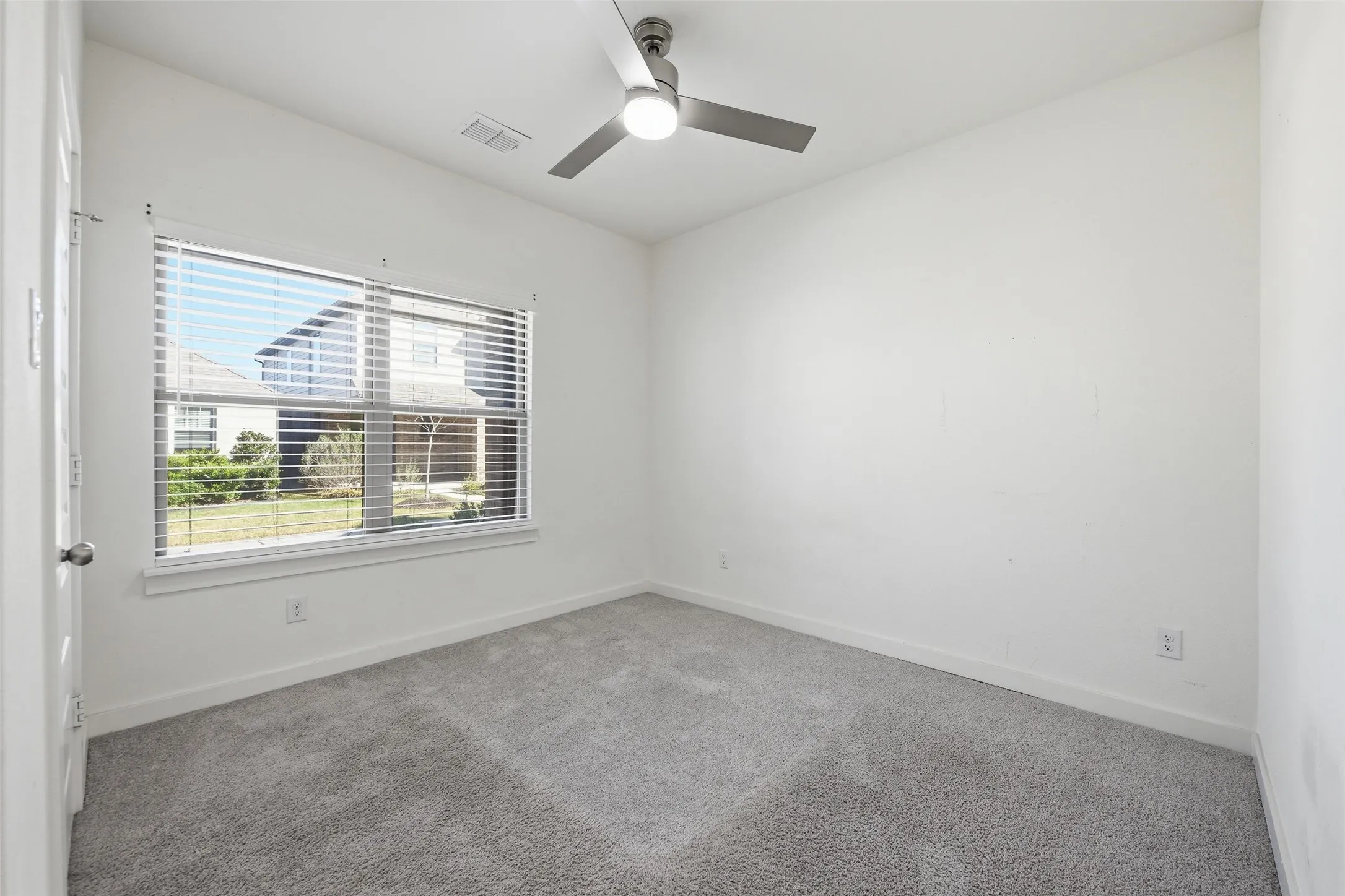 Spare room with carpet and a ceiling fan