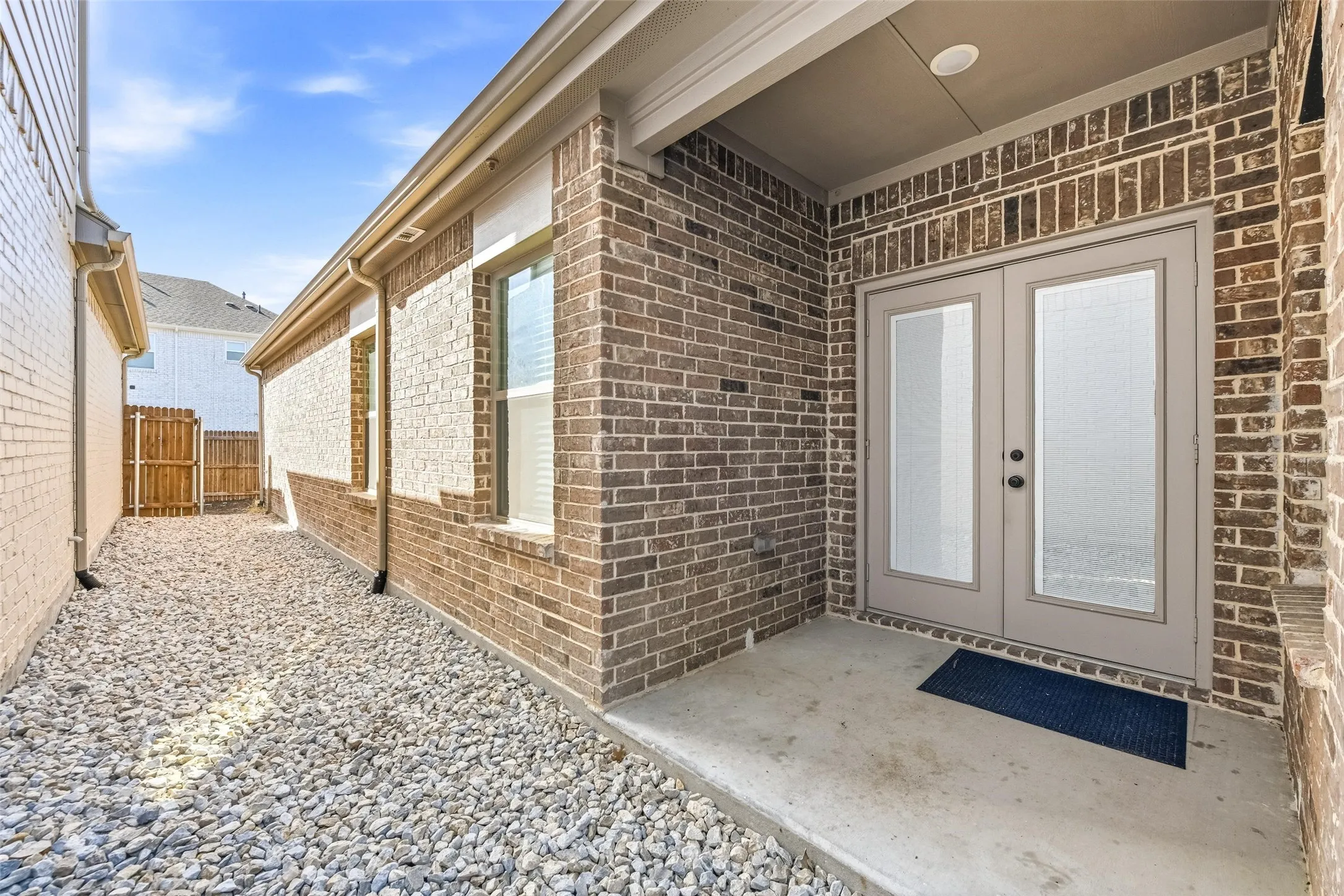 Doorway to property featuring brick siding, french doors, and a patio area