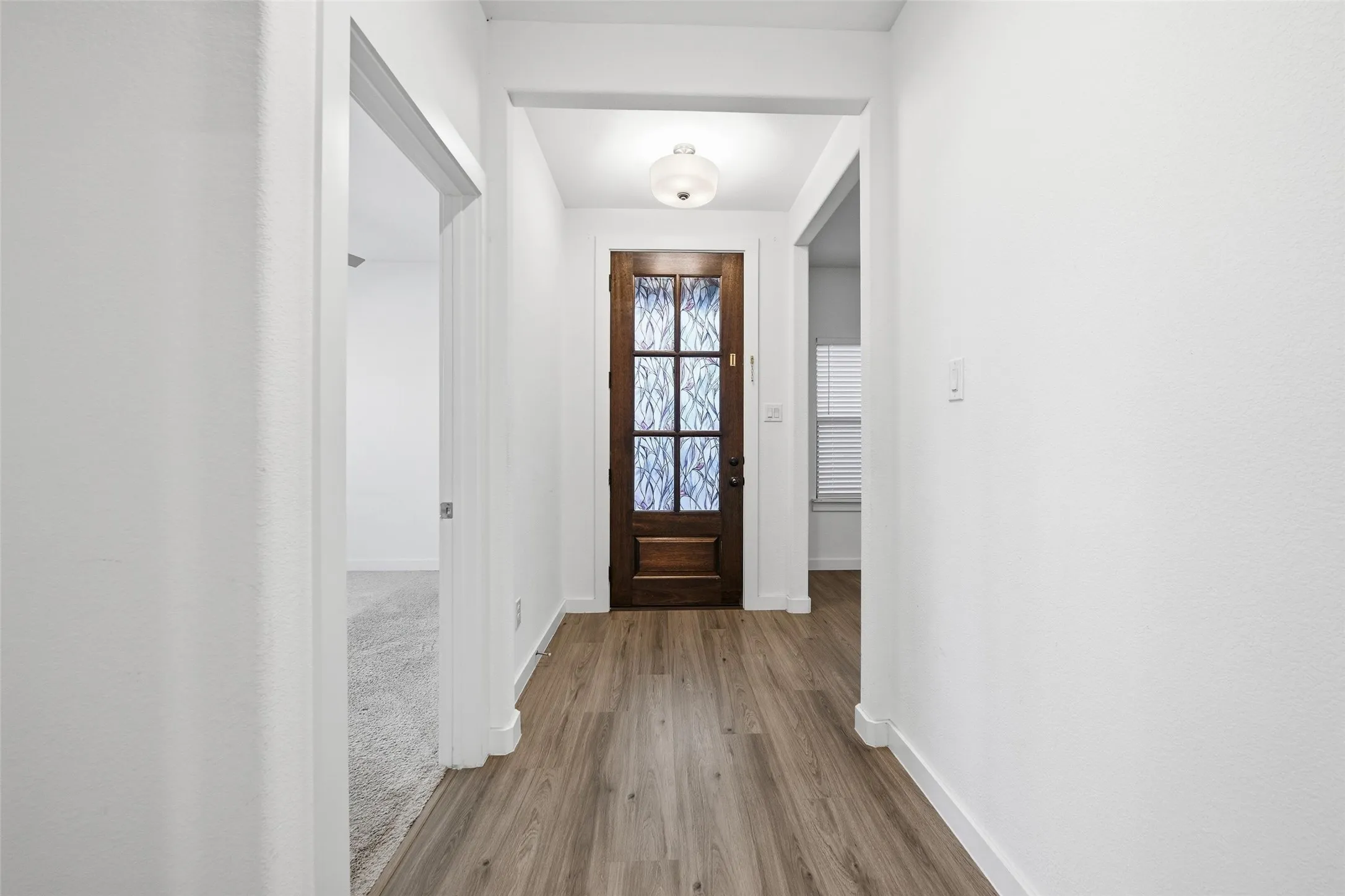 Entryway featuring baseboards and wood finished floors