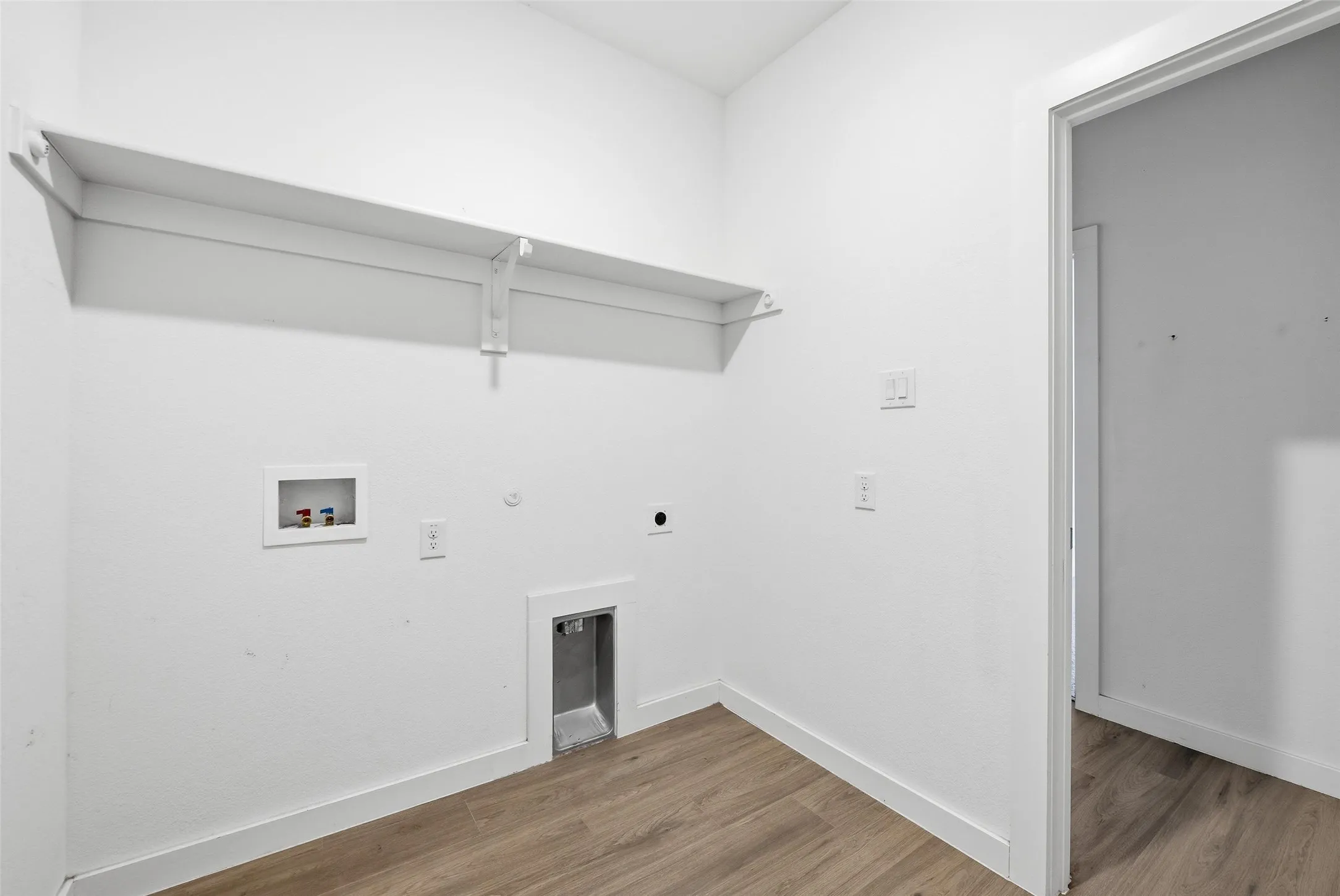 Laundry area featuring hookup for a gas dryer, electric dryer hookup, wood finished floors, and washer hookup