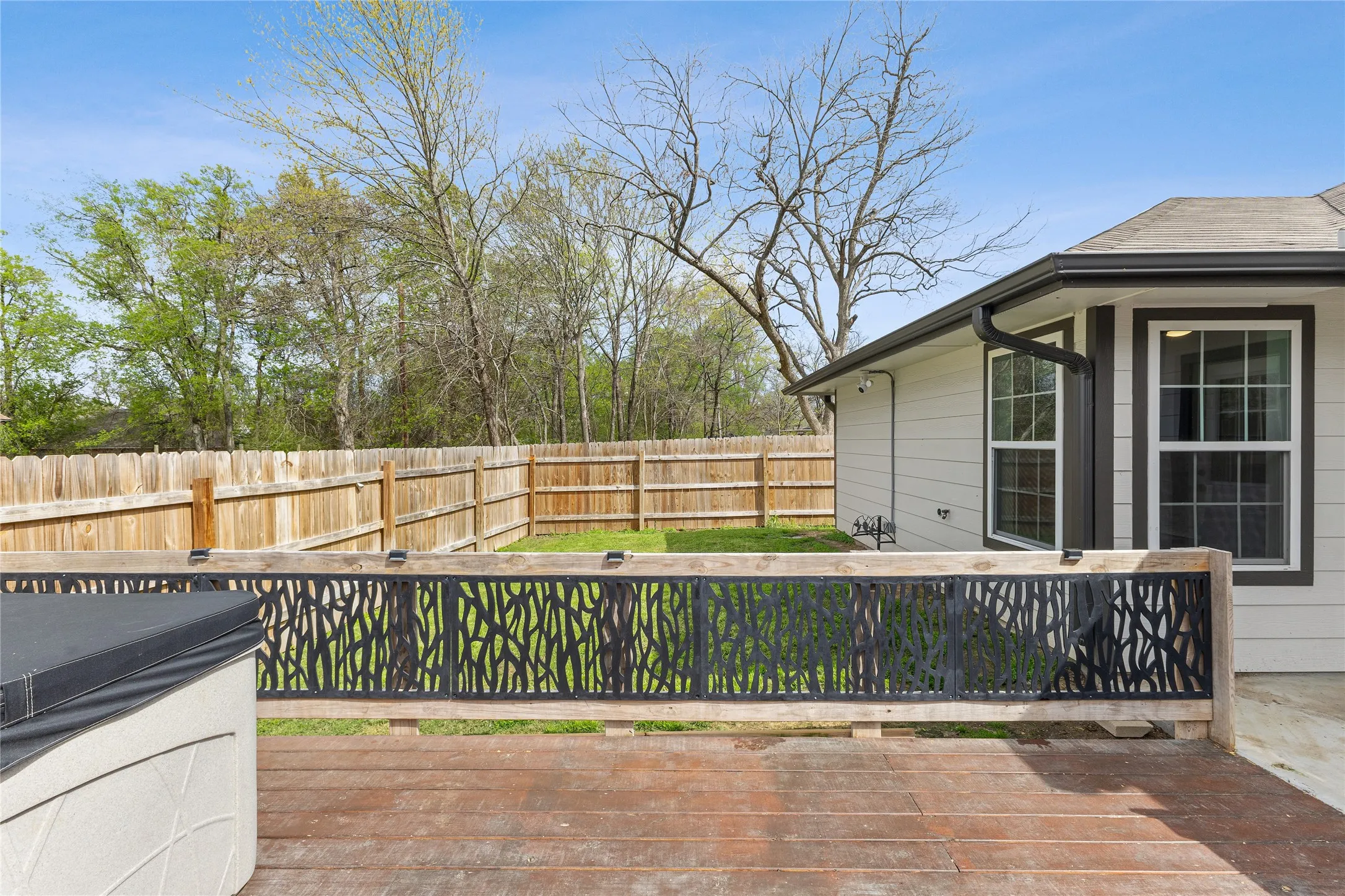 Wooden deck with a fenced backyard