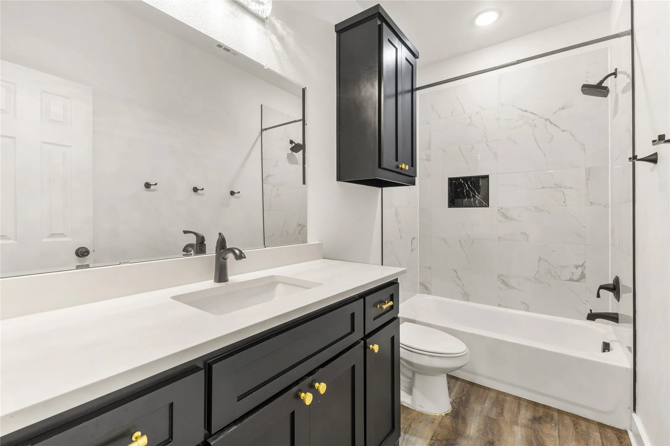 Bathroom with vanity, bathtub / shower combination, and dark wood-style floors