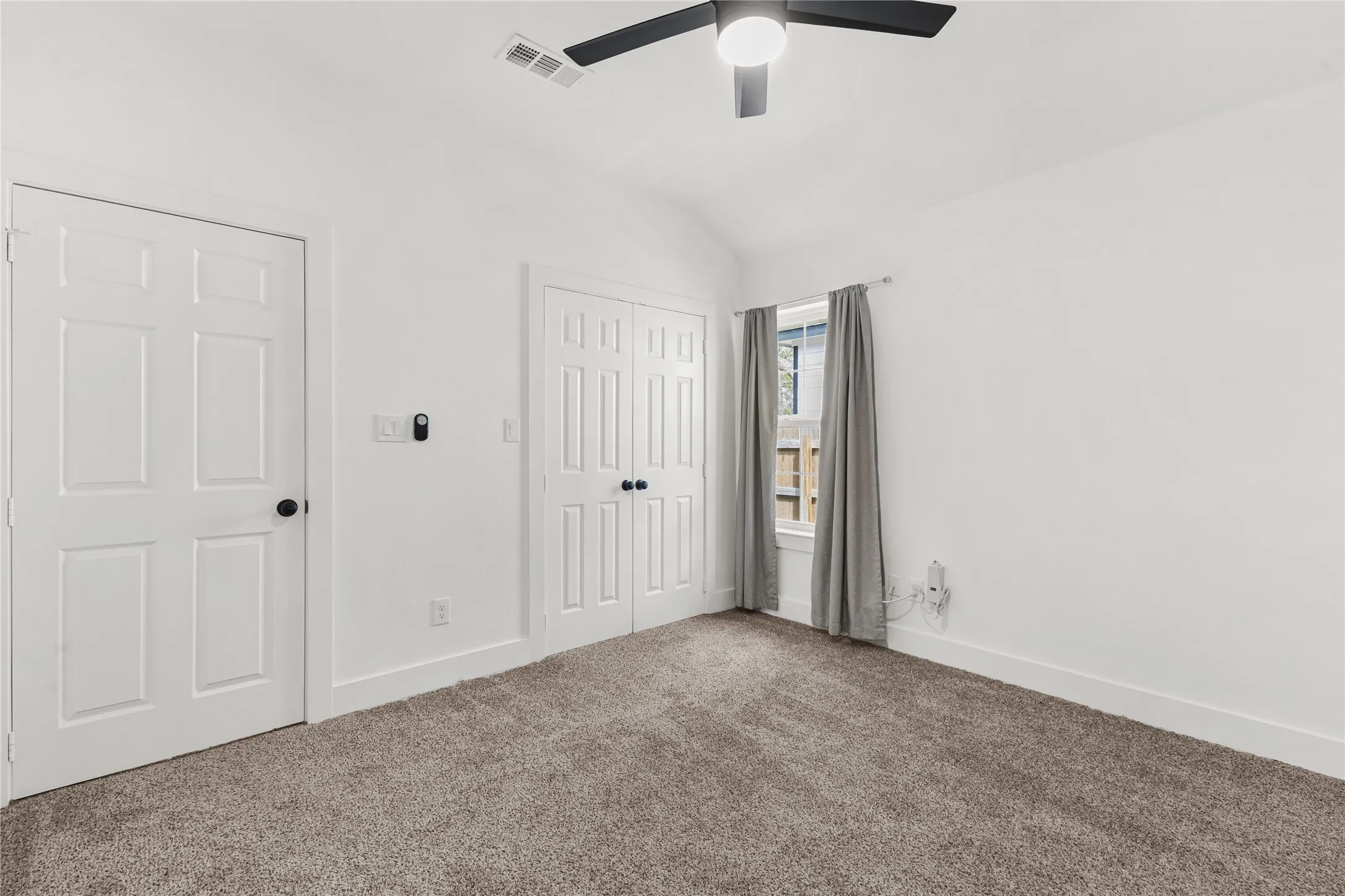 Unfurnished bedroom with a closet, carpet floors, lofted ceiling, and a ceiling fan