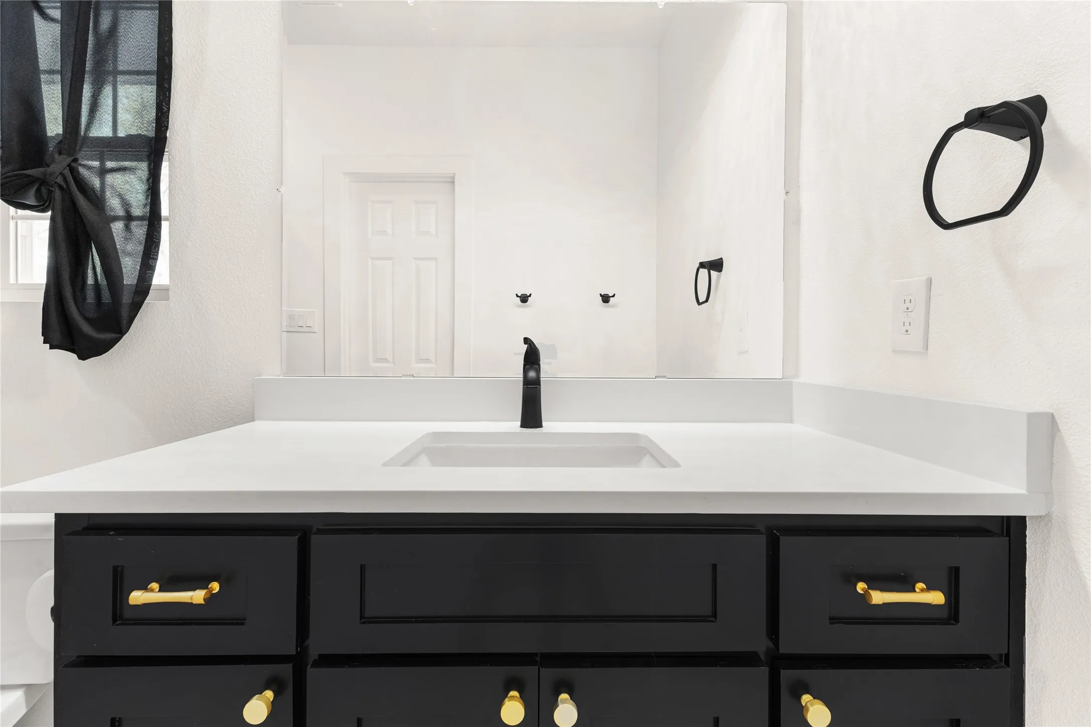 Bathroom featuring vanity and a textured wall