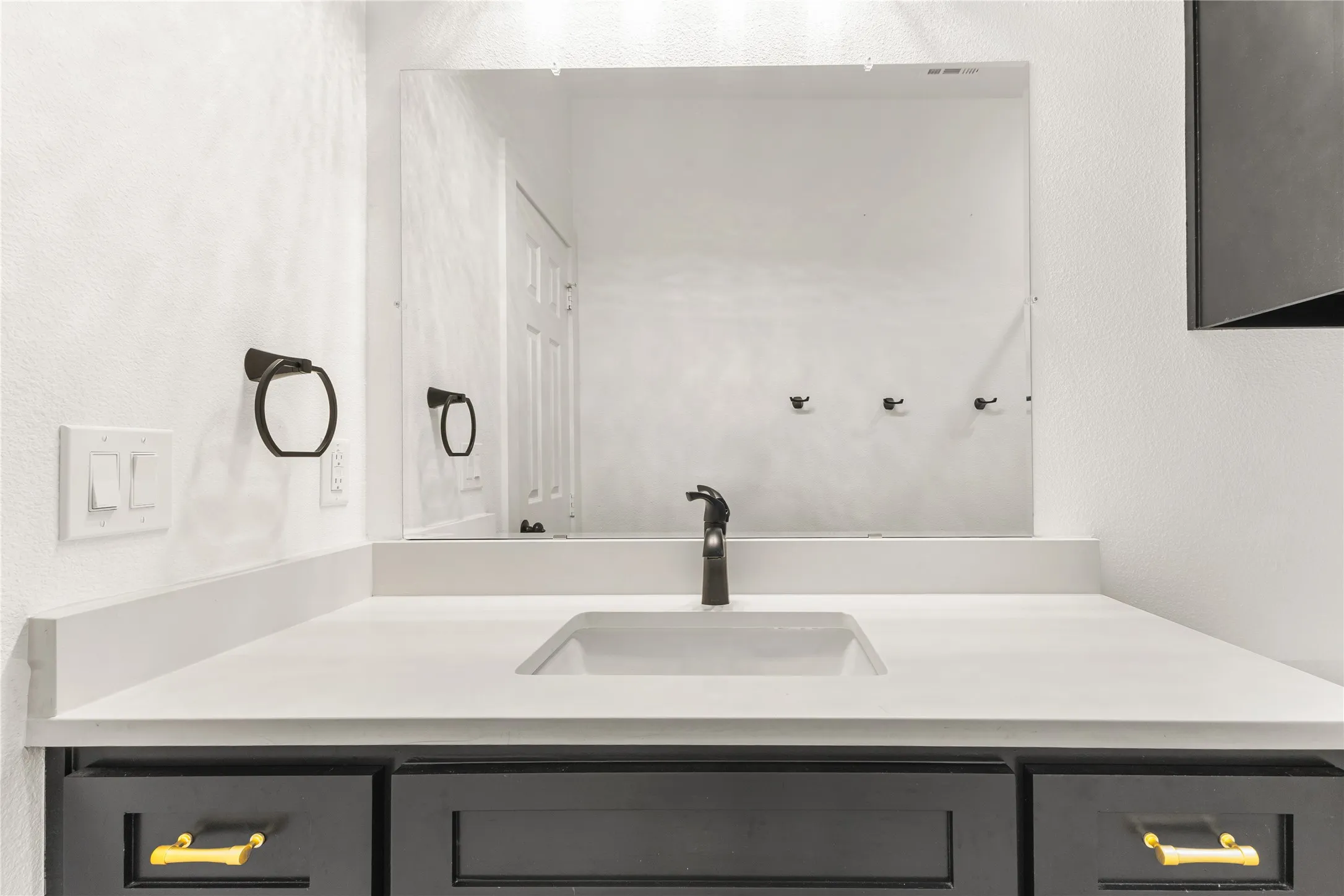Bathroom with vanity and a textured wall