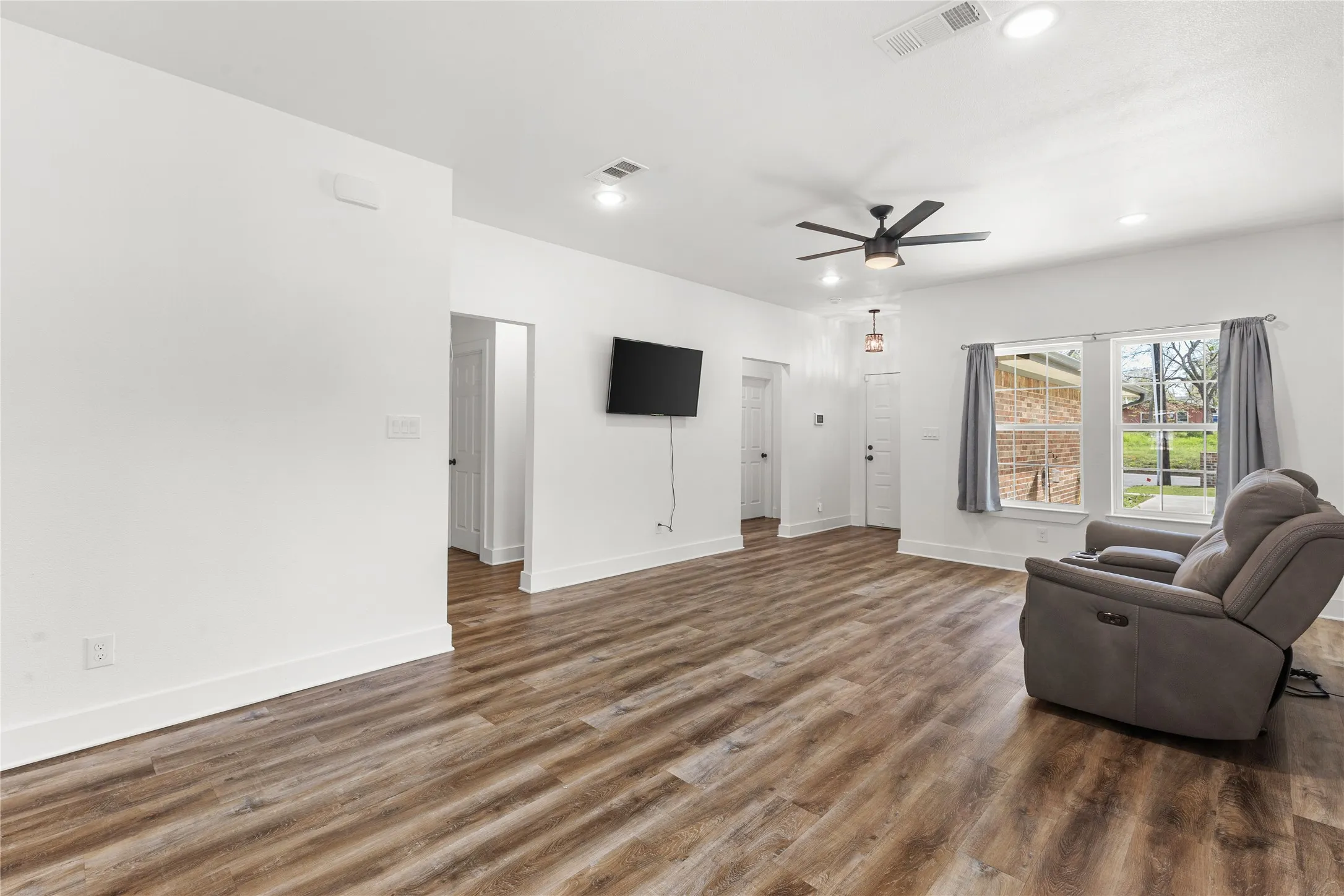 Living area featuring dark wood finished floors, recessed lighting, and a ceiling fan
