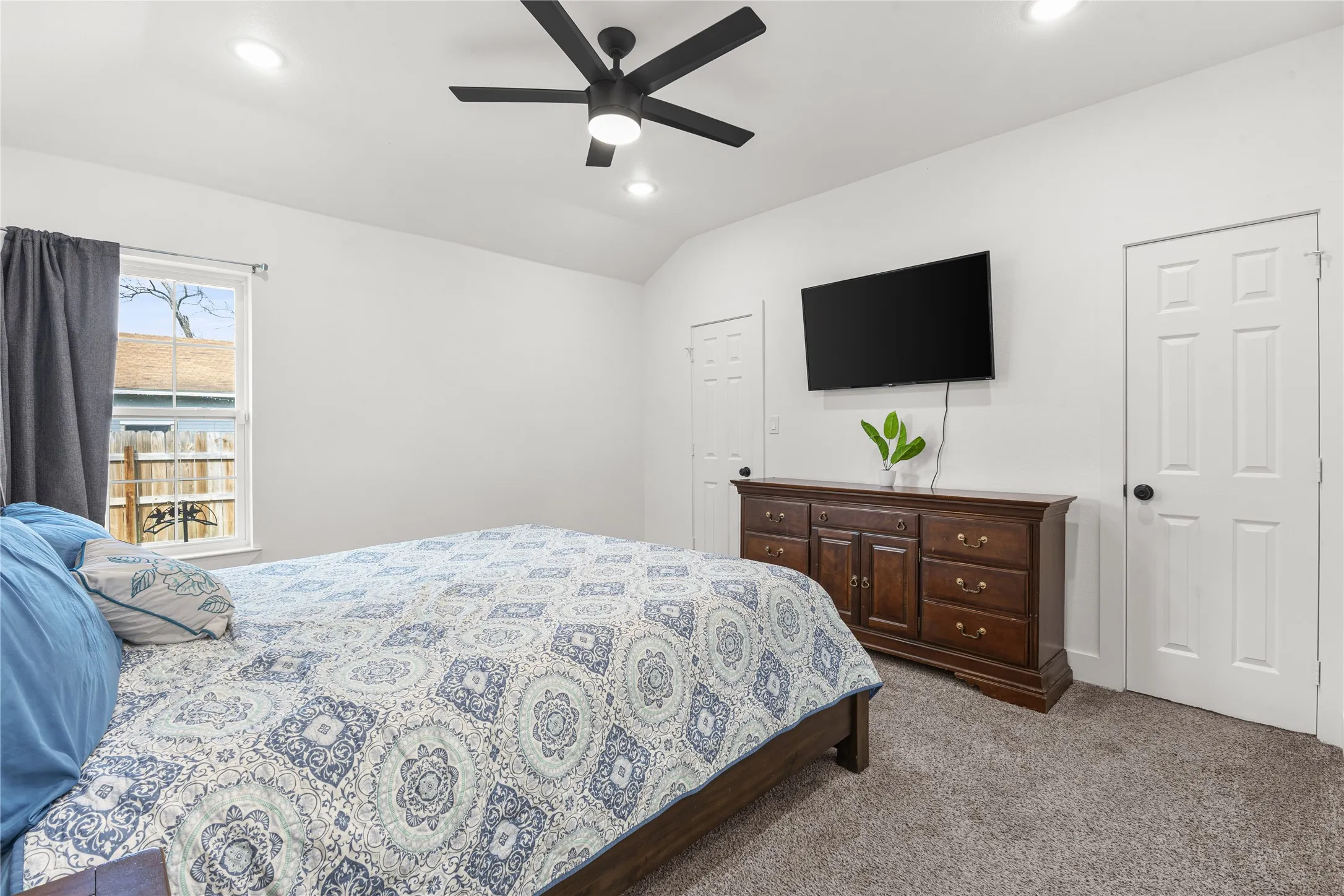 Bedroom with dark colored carpet, a ceiling fan, recessed lighting, and vaulted ceiling