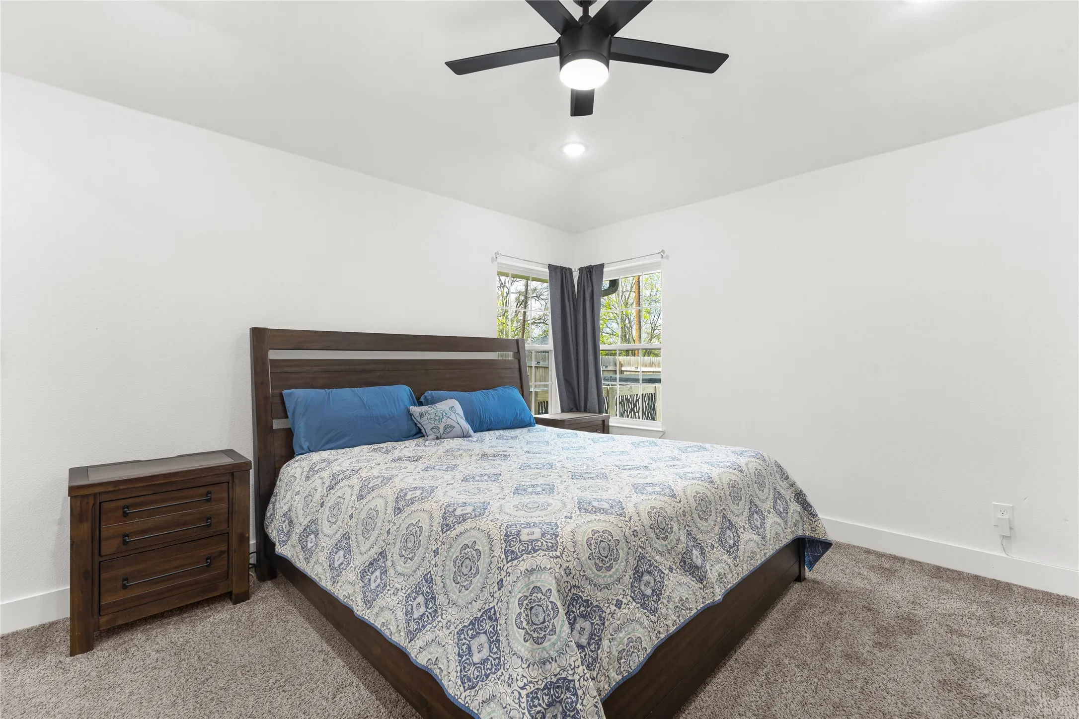 Bedroom featuring a ceiling fan, carpet, and vaulted ceiling