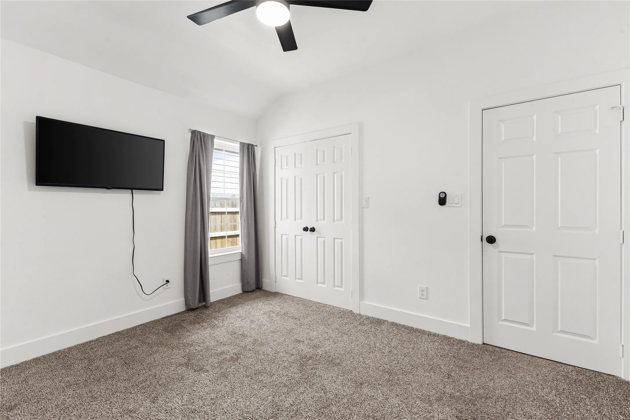 Unfurnished bedroom with carpet floors, a closet, vaulted ceiling, and a ceiling fan