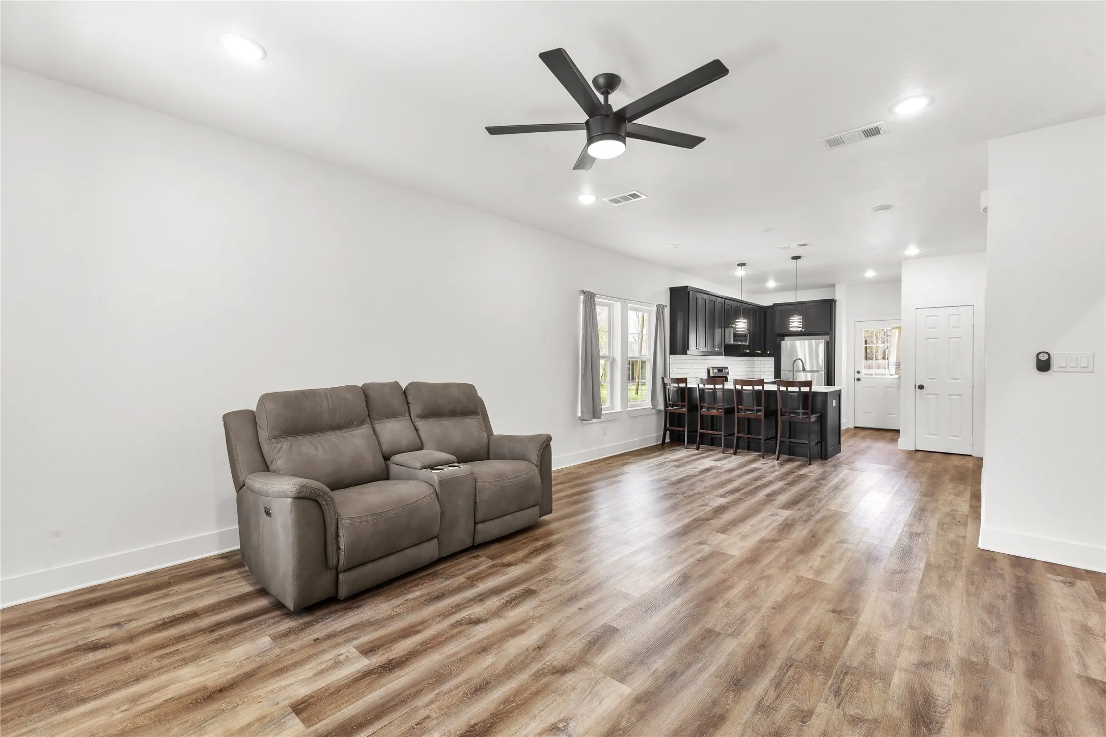 Living area featuring ceiling fan, light wood-type flooring, and recessed lighting