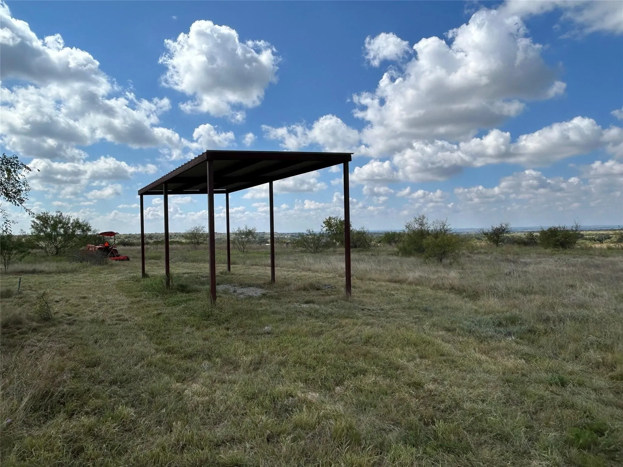 View of yard with a rural view and a carport