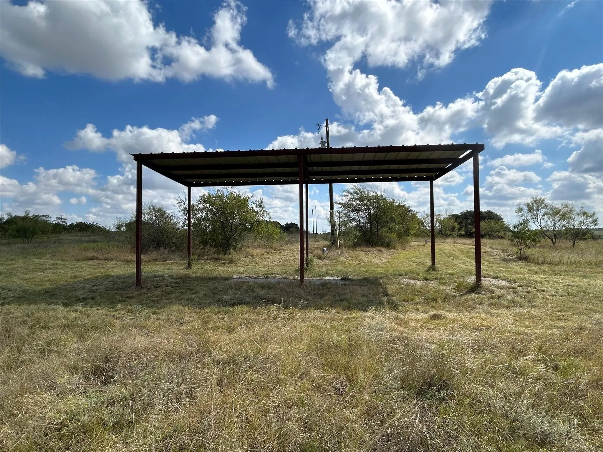 View of yard featuring a detached carport and a view of rural / pastoral area