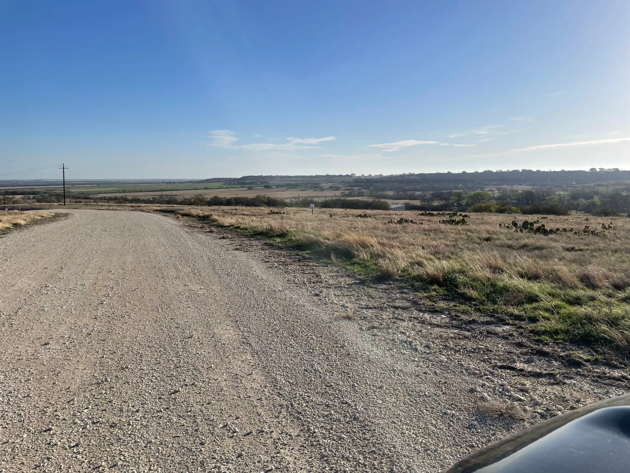 View of dirt / gravel road featuring a view of rural / pastoral area