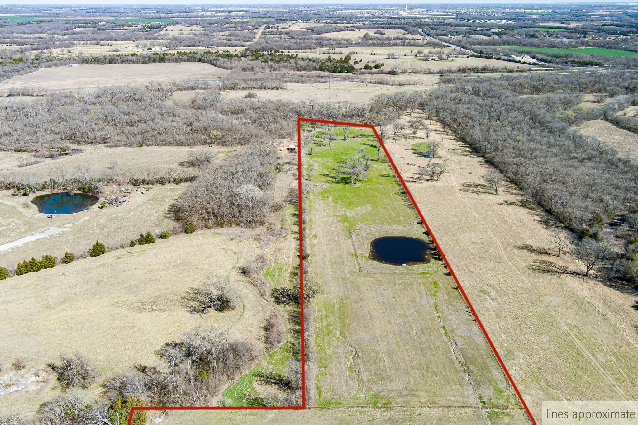 Aerial view of sparsely populated area with property parcel outlined and a nearby body of water