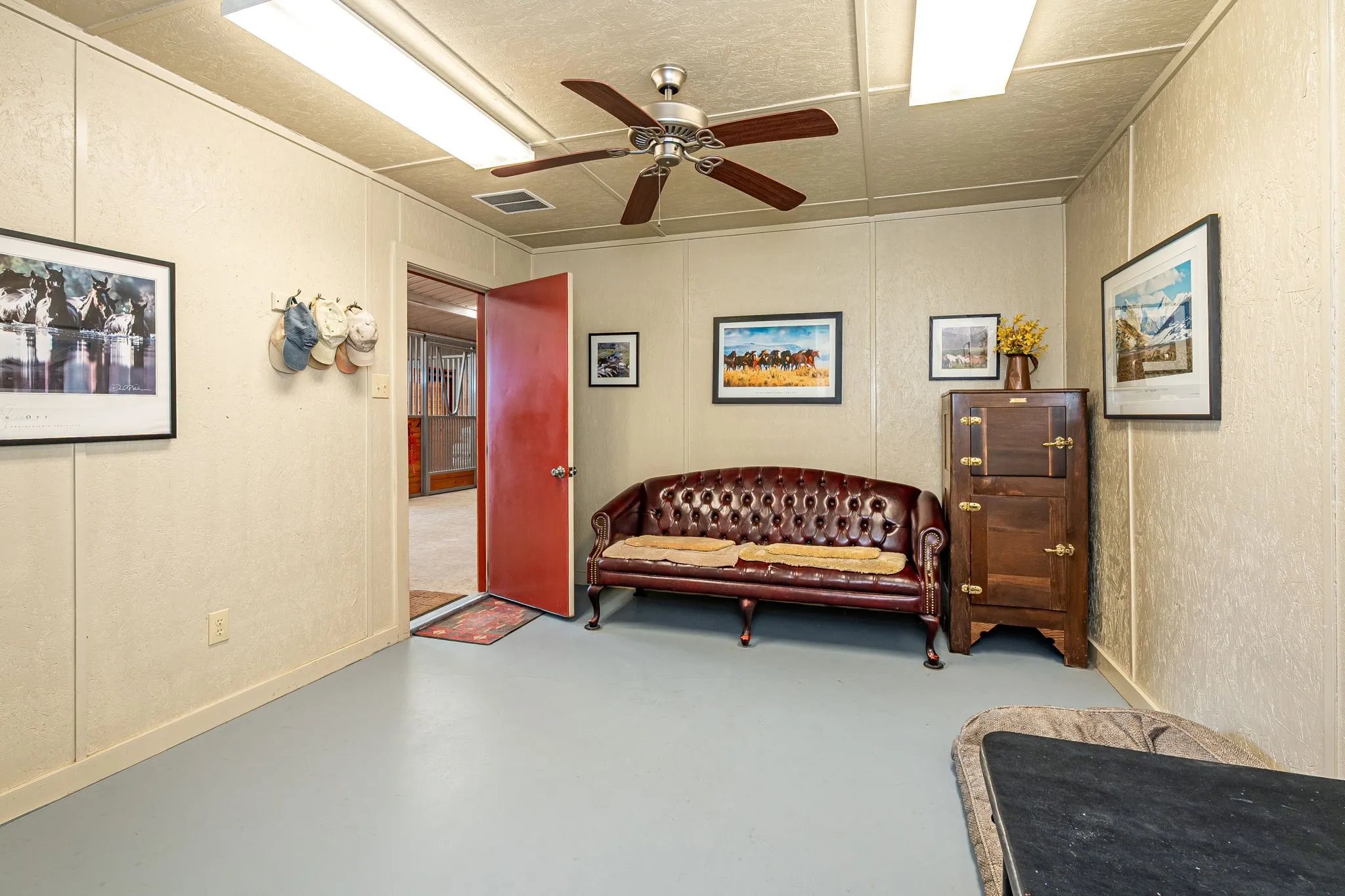Sitting room with finished concrete floors and a ceiling fan