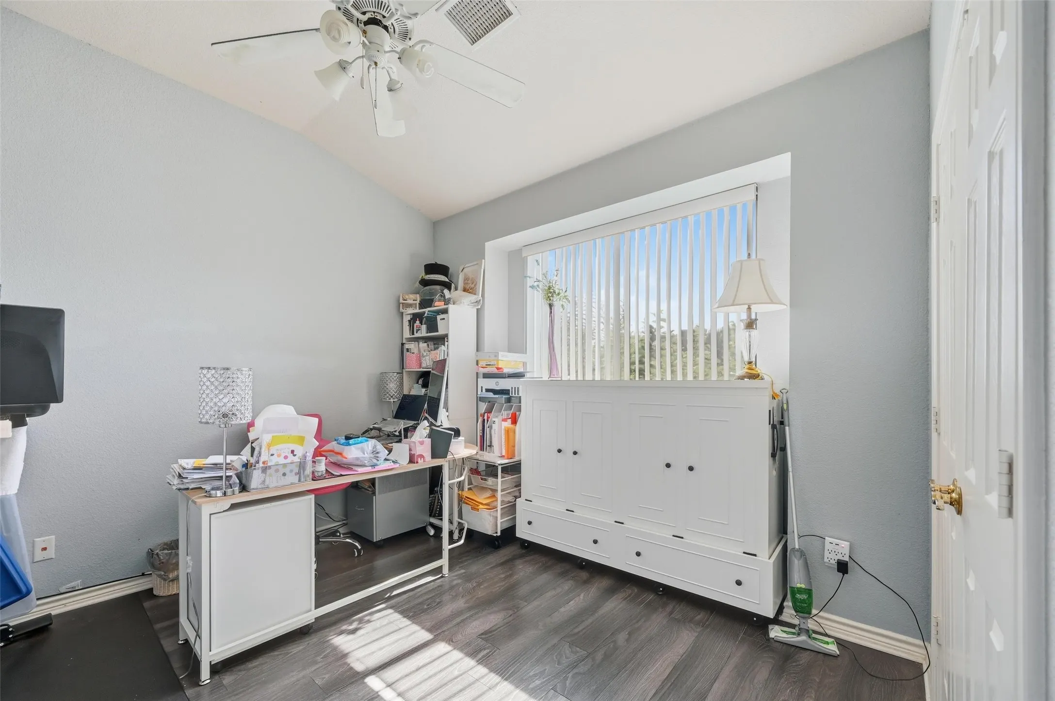 Office area with vaulted ceiling, dark wood-type flooring, and ceiling fan