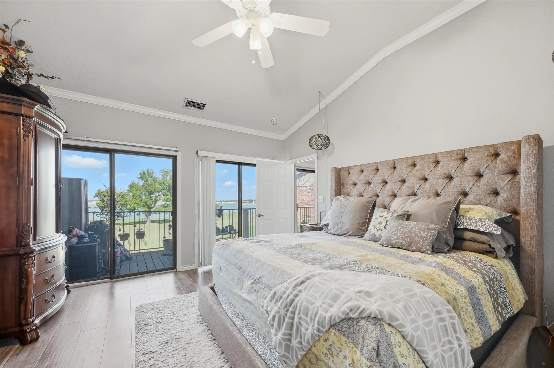 Bedroom with ornamental molding, wood finished floors, access to outside, high vaulted ceiling, and ceiling fan