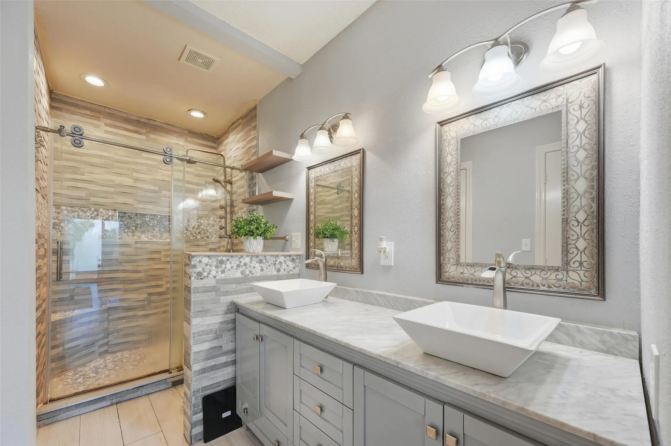 Full bath with double vanity, a shower stall, and recessed lighting