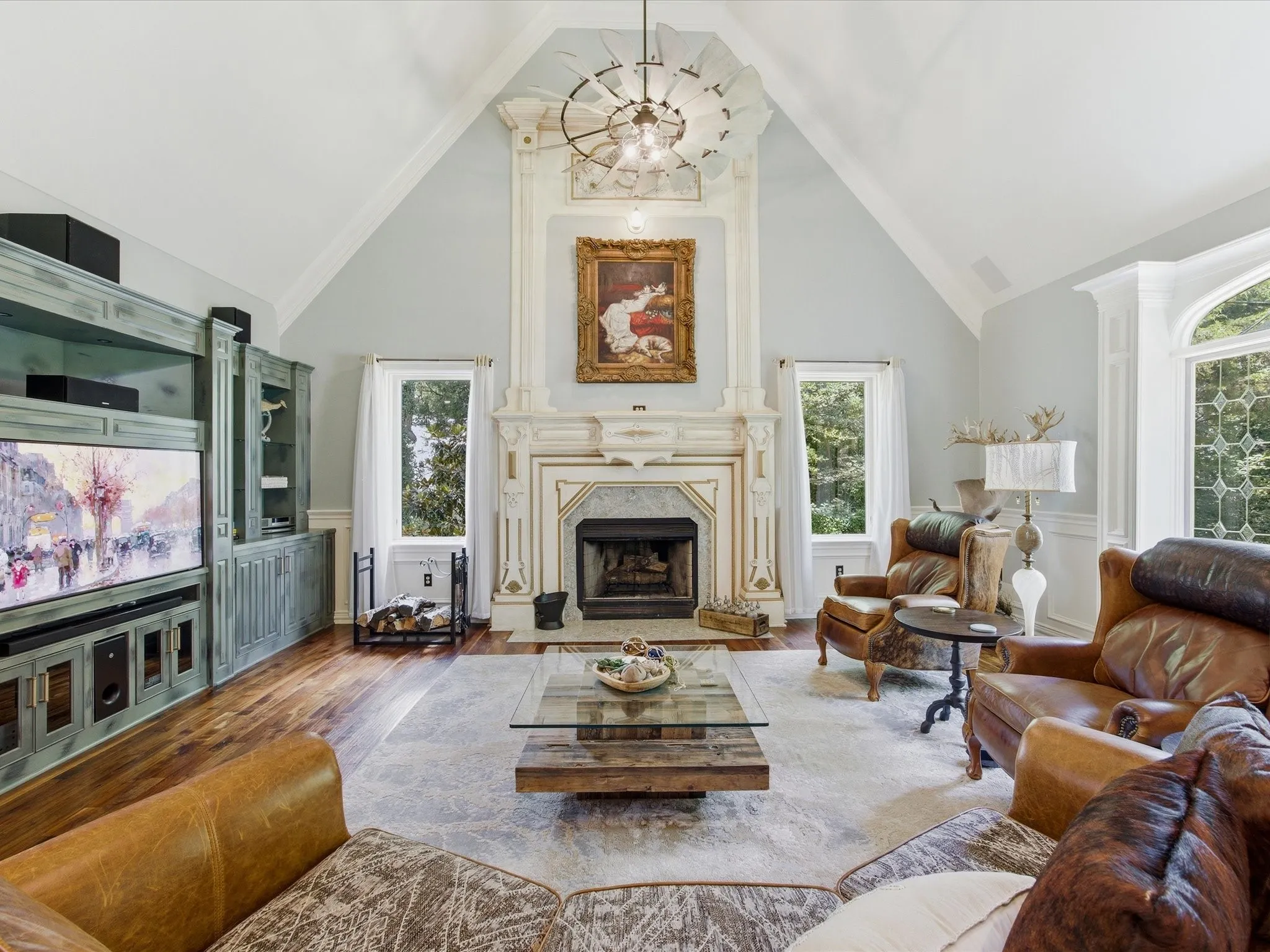 Living area featuring a vaulted ceiling, wood-finish flooring, and a floor-to-ceiling decorative fireplace with mantel