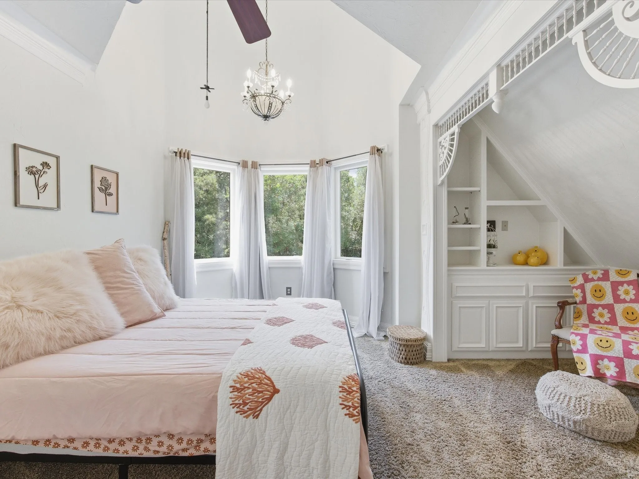Bright interior space featuring a multi-pane bay window, vaulted ceiling, and recessed shelving