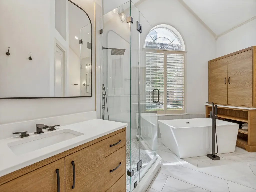 Free standing tub, glass shower, and separate vanities.