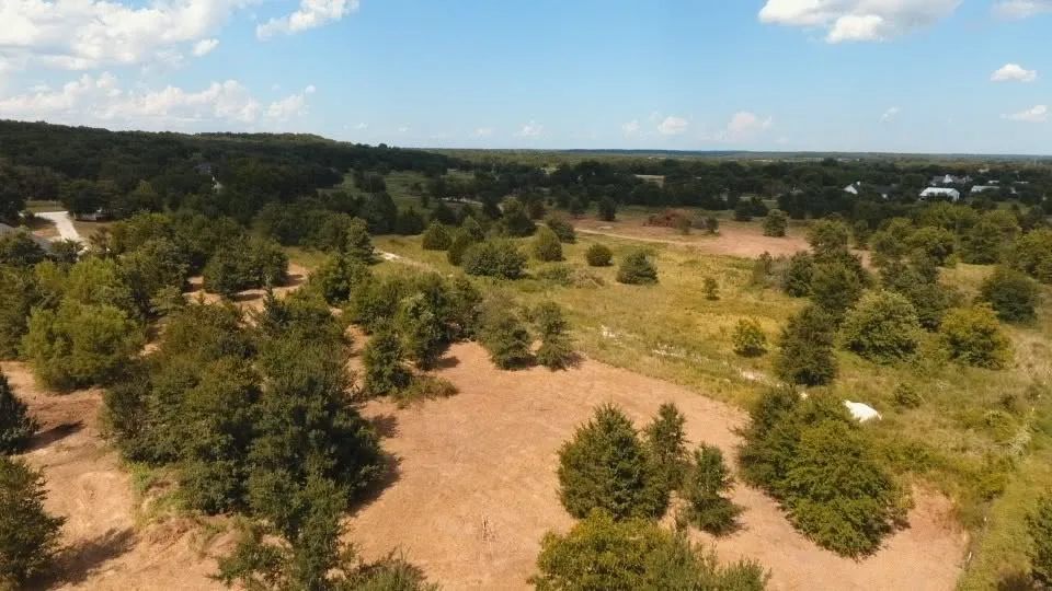 Expansive rural land featuring a mix of mature trees and open fields