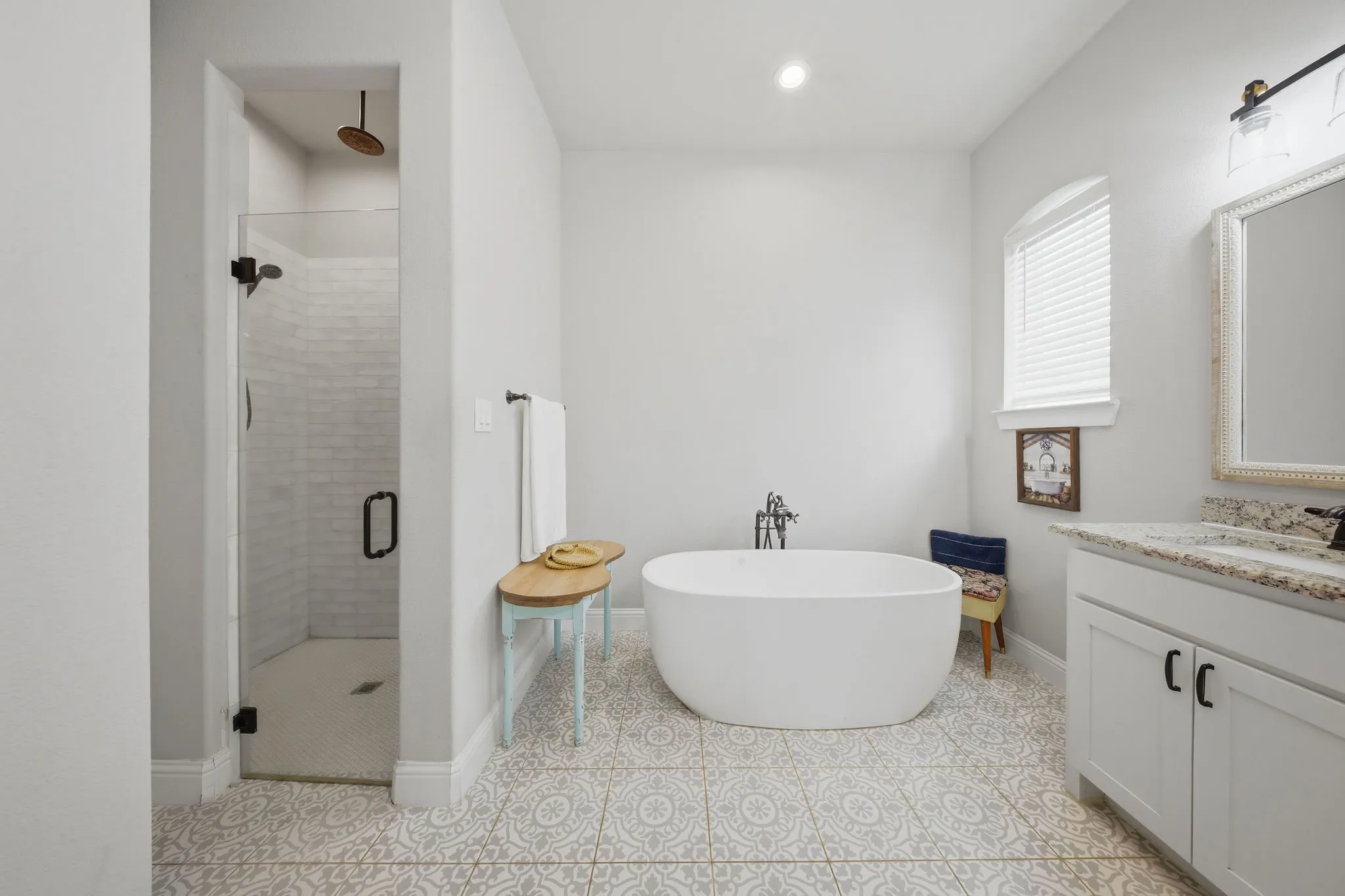 Bathroom featuring vanity, a shower stall, a freestanding tub, light tile patterned flooring, and recessed lighting