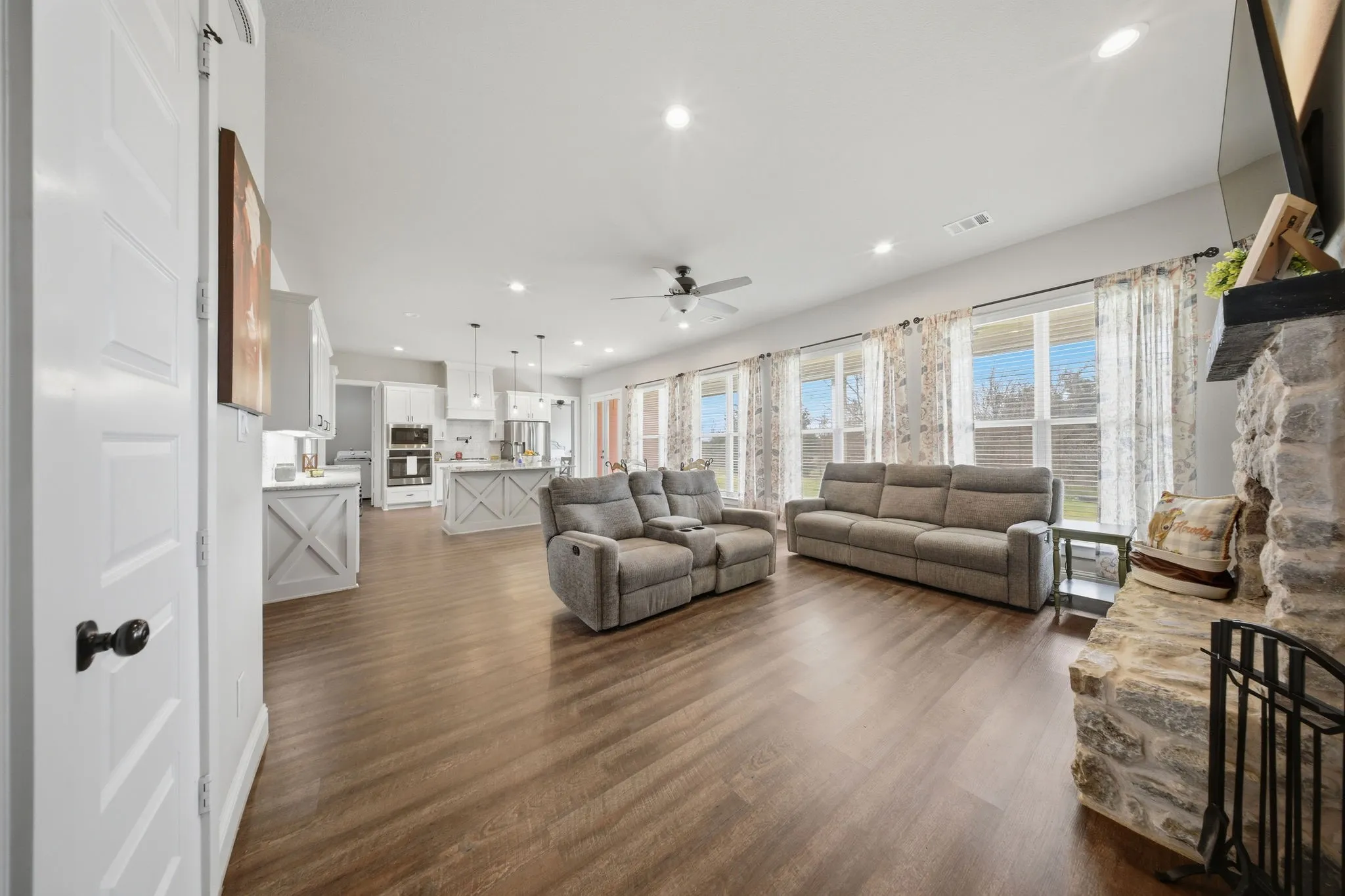 Living room featuring dark wood-type flooring, ceiling fan, and recessed lighting
