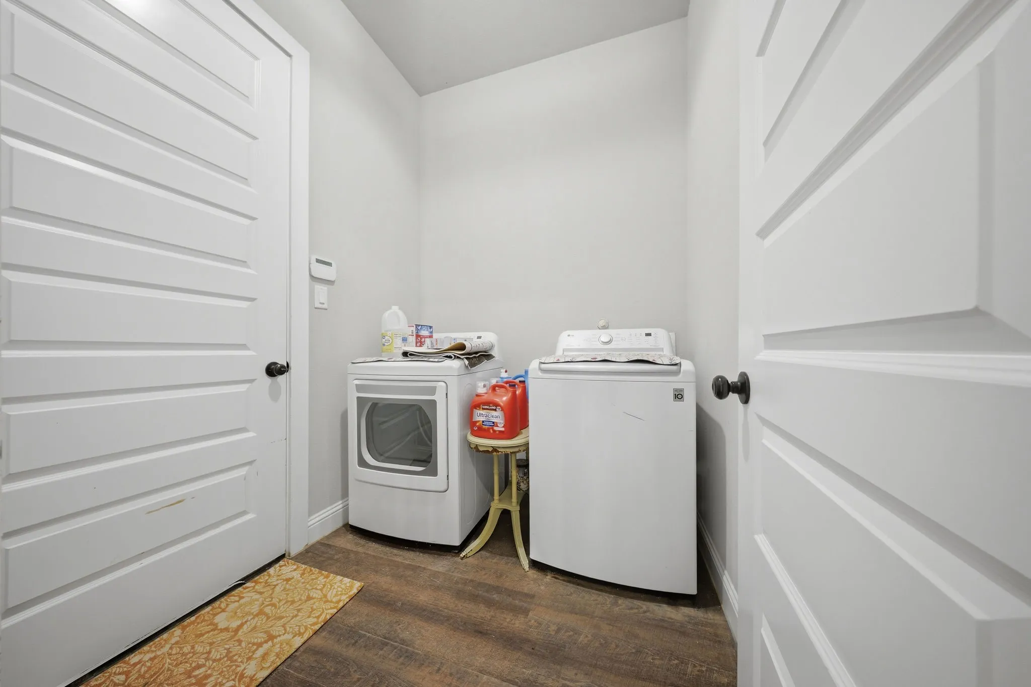 Laundry room with dark wood-style flooring and washer and clothes dryer