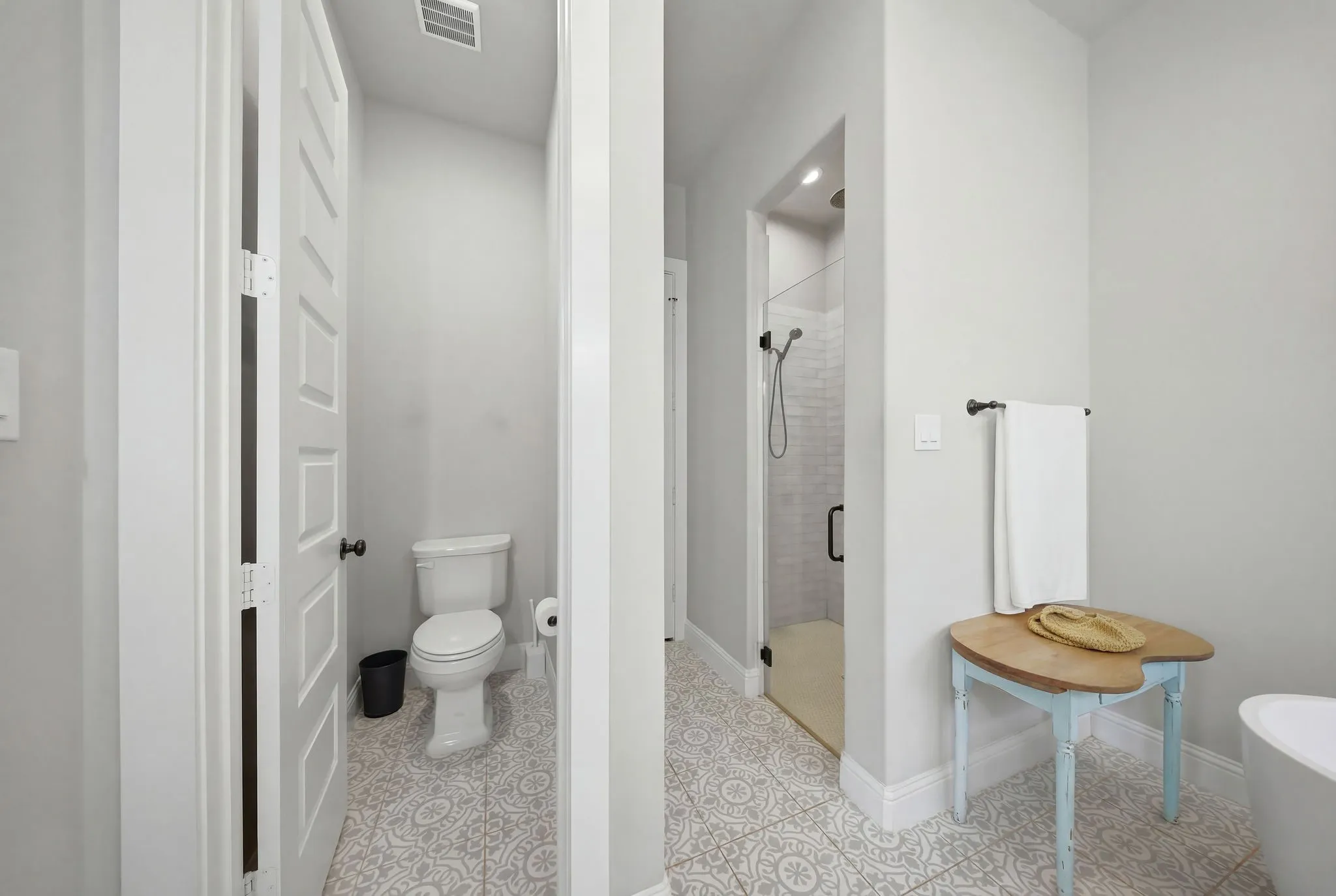 Full bathroom featuring a stall shower, a freestanding tub, and light tile patterned floors