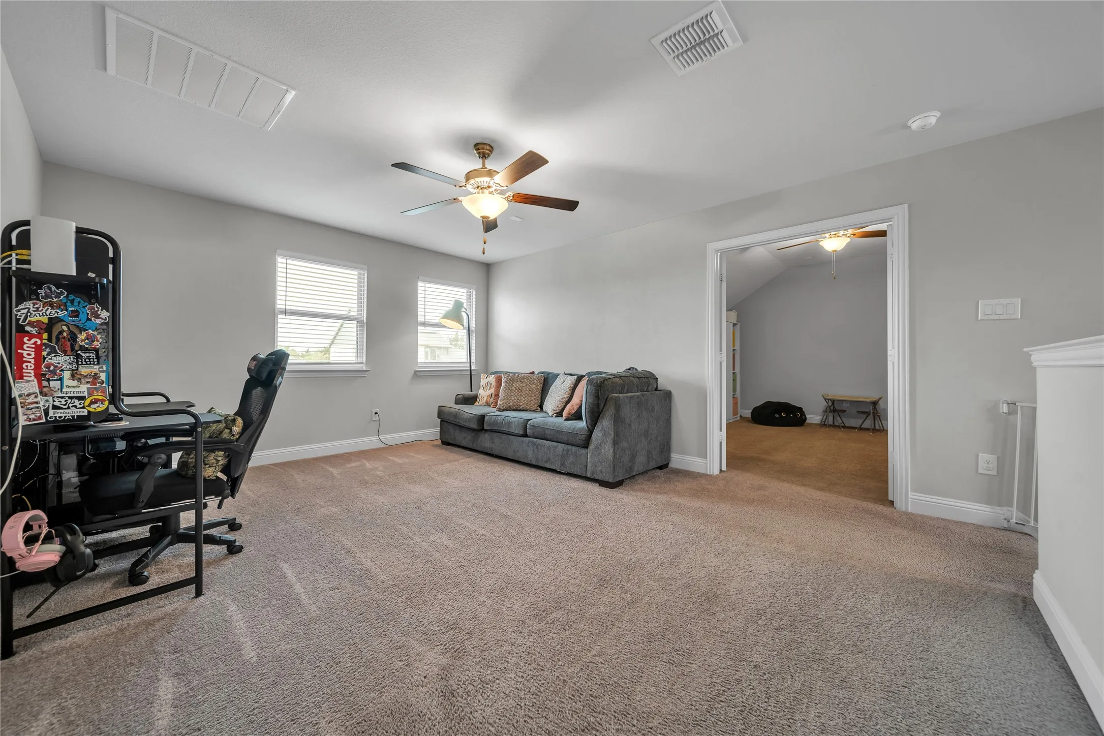 Office space with a ceiling fan and light carpet
