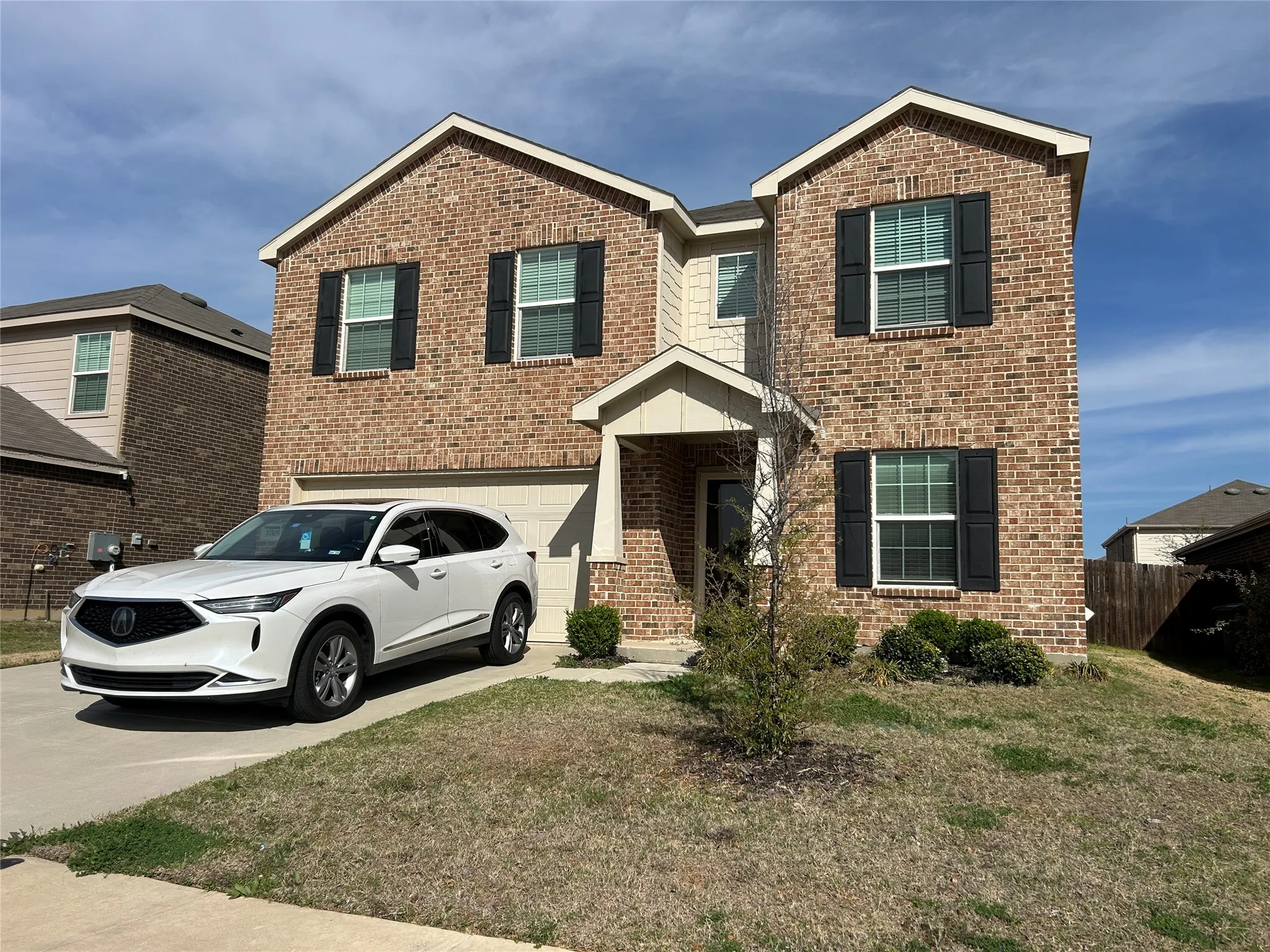 View of front of property with brick siding, concrete driveway, and an attached garage