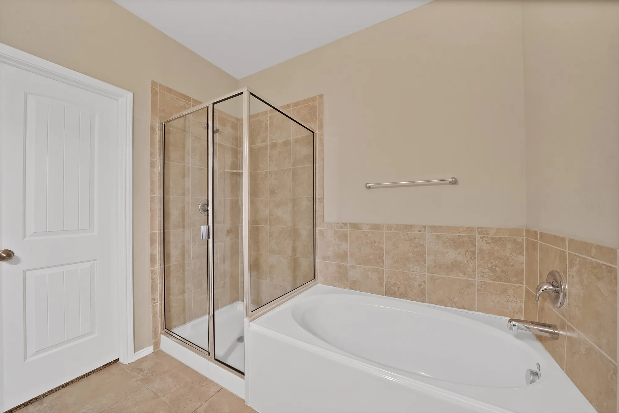 Bathroom featuring a garden tub, a shower stall, and light tile patterned floors